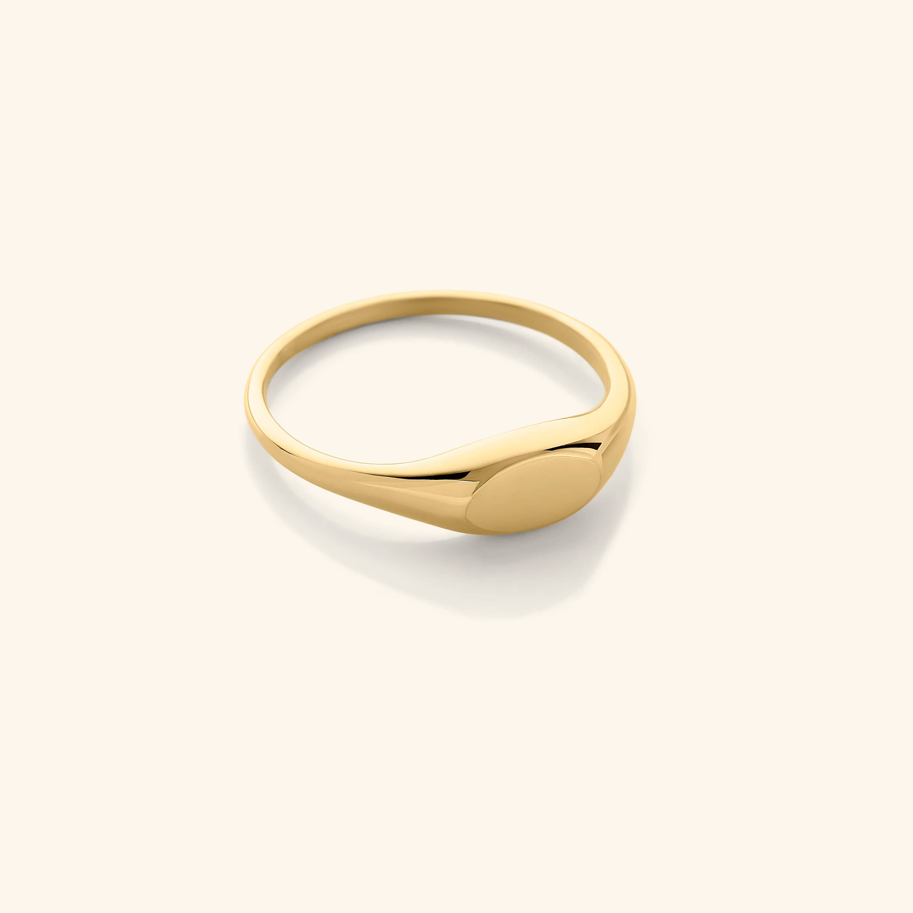Gold signet ring displayed on a velvet pouch, highlighting its sleek design