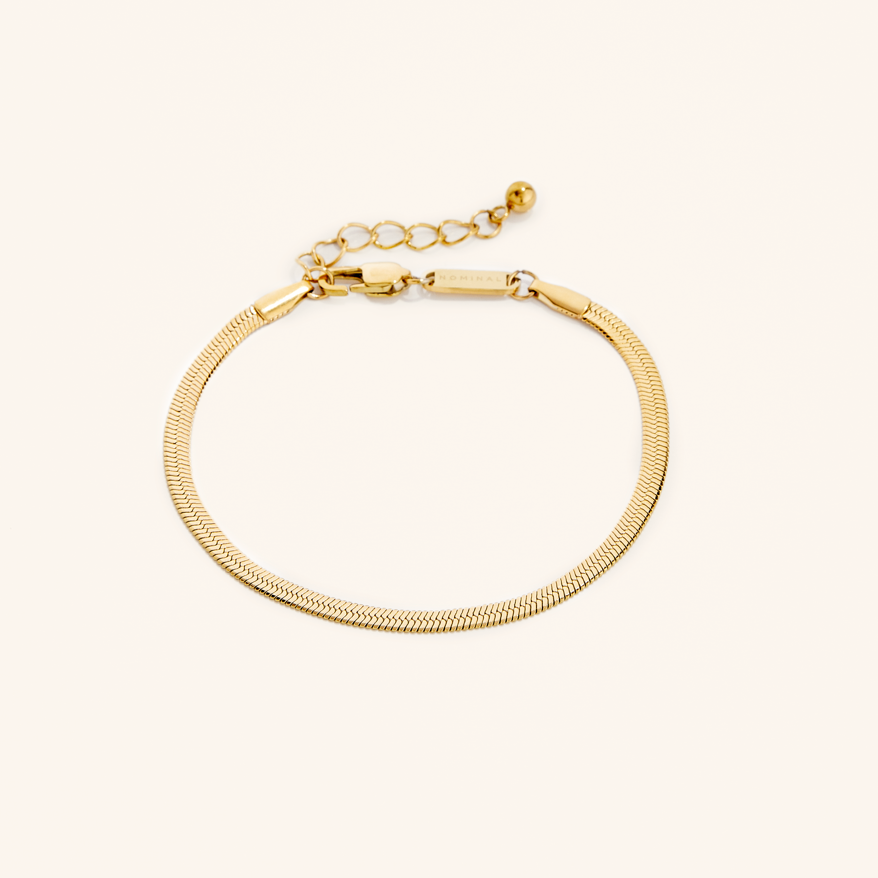 Classic herringbone bracelet displayed elegantly on a wrist, showcasing its luxurious gold finish.