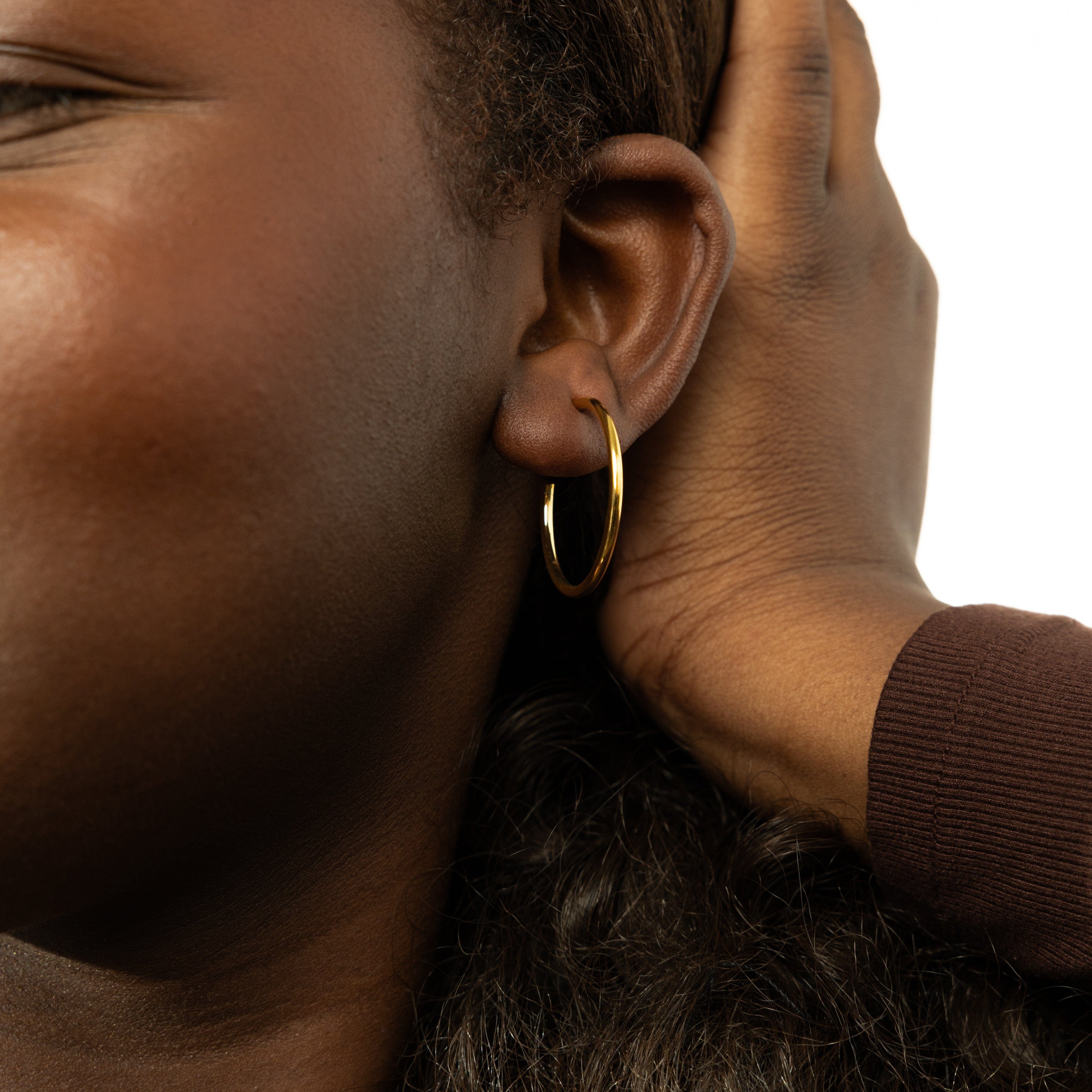 Close-up of 26mm hoop earrings, highlighting the quality of the 18 Karat gold finish.