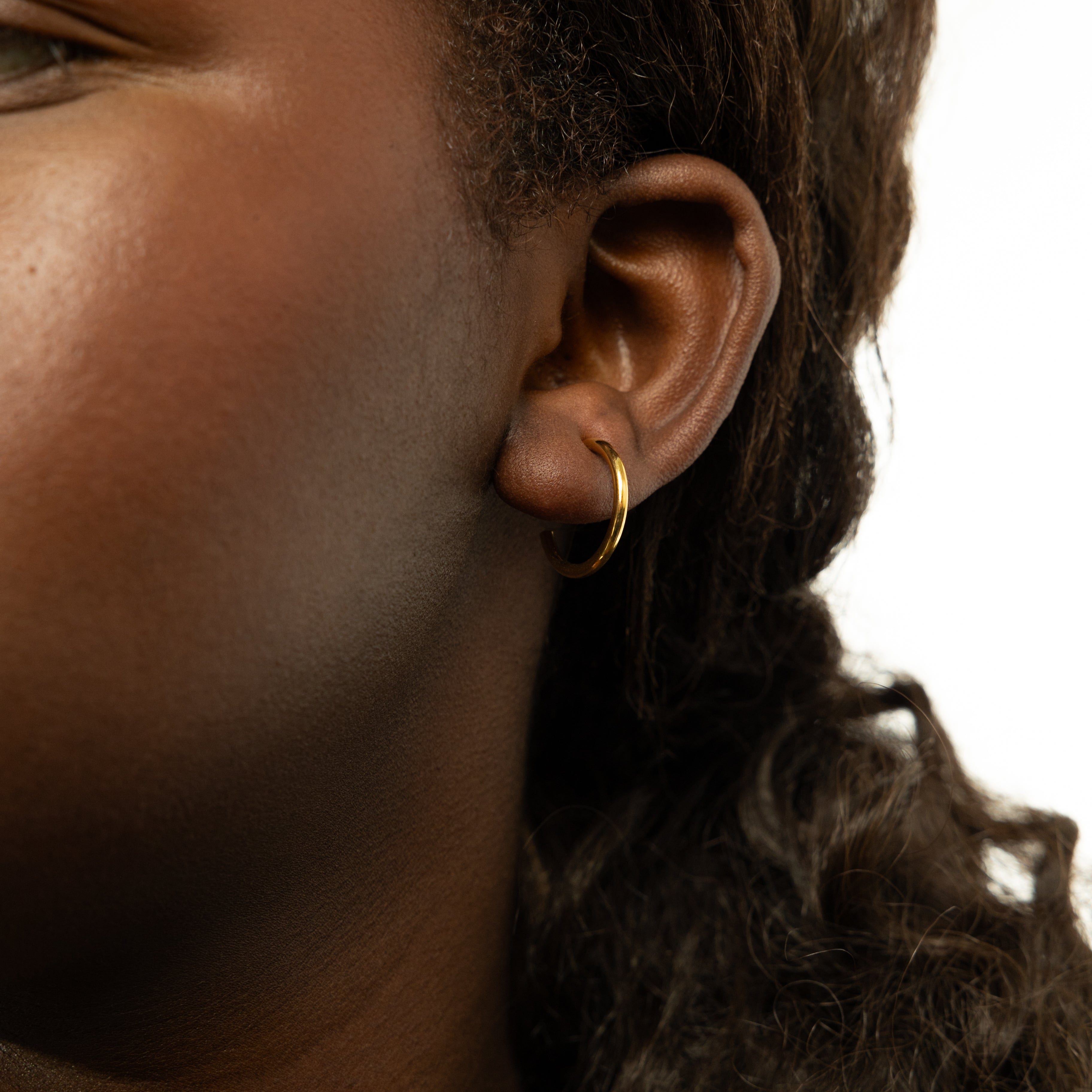 Front view of Everyday Luxe 18mm gold hoop earrings showcasing their shine.