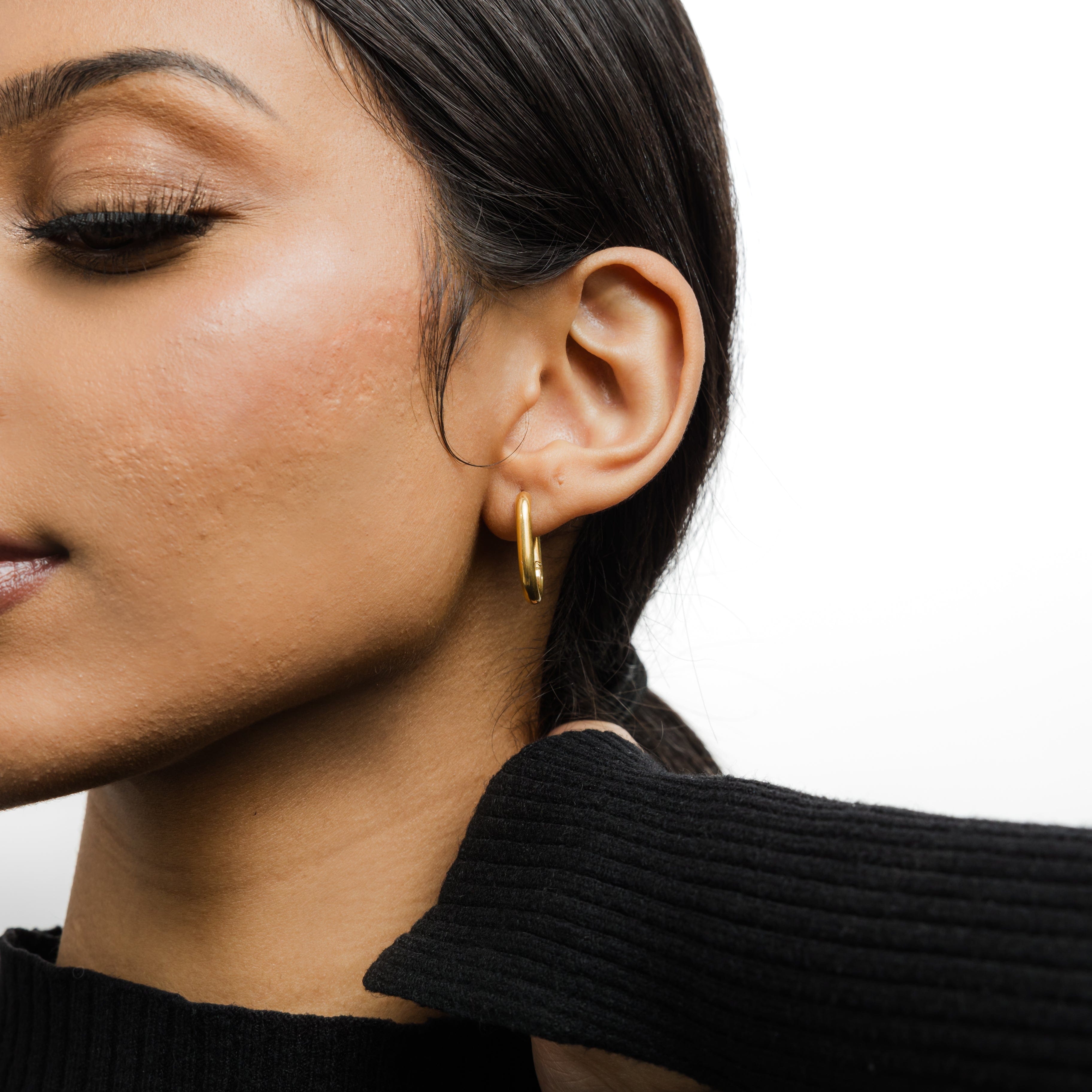 Essential Gold Oval Hoop Earrings displayed in a Nominal pouch.
