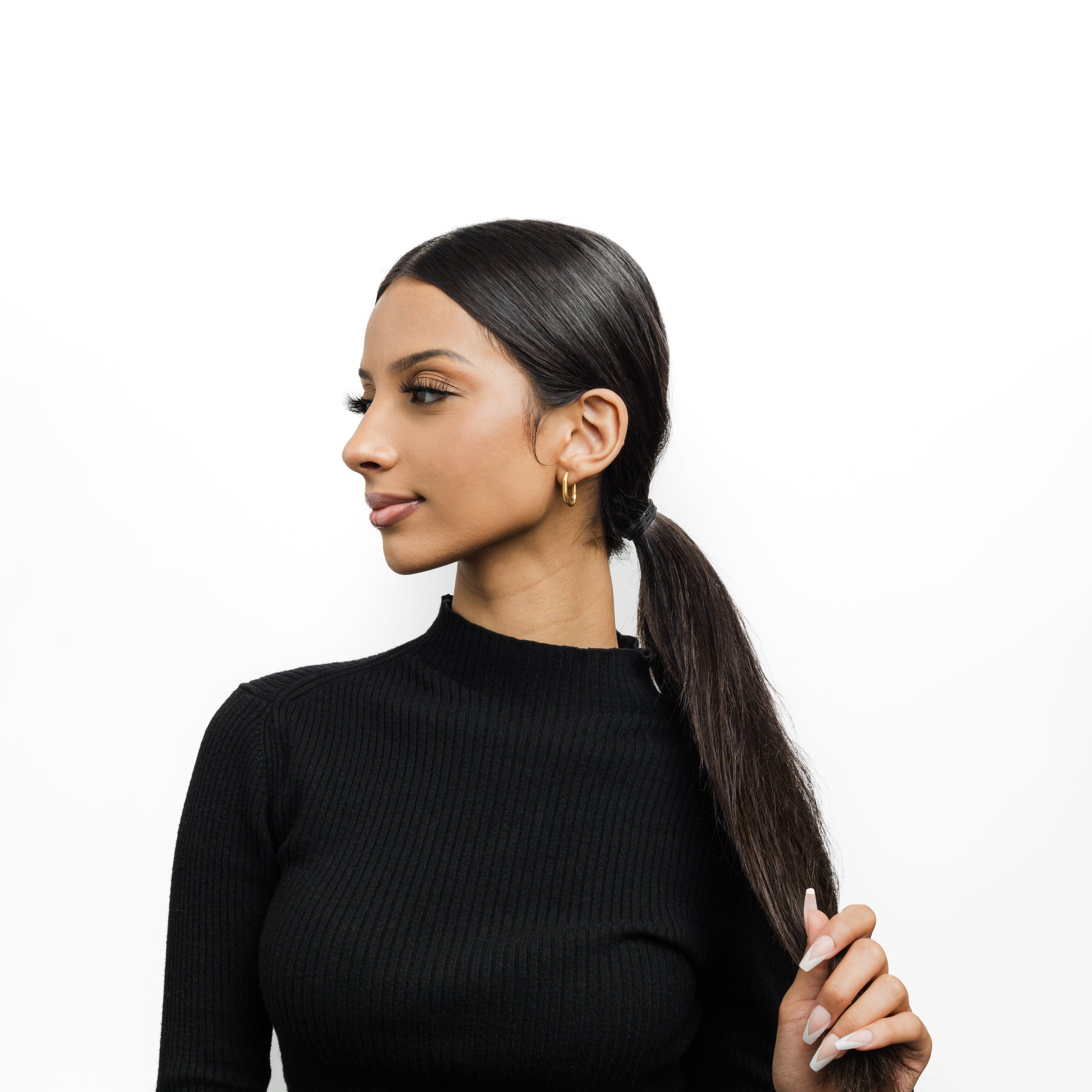 Close-up of Essential Gold Oval Hoop Earrings showcasing the shiny gold finish.