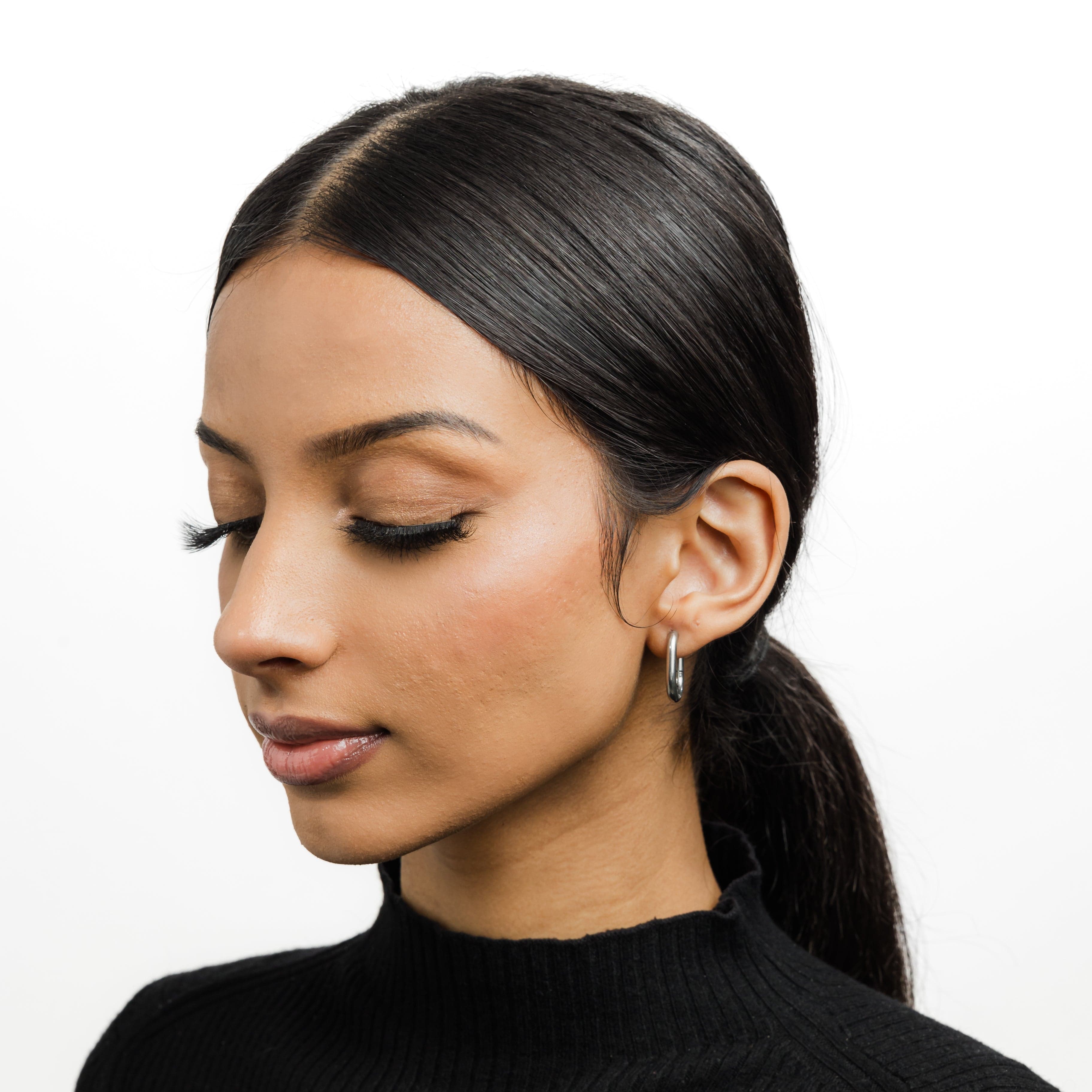 Close-up of Essential Gold Oval Hoop Earrings showcasing the shiny gold finish.