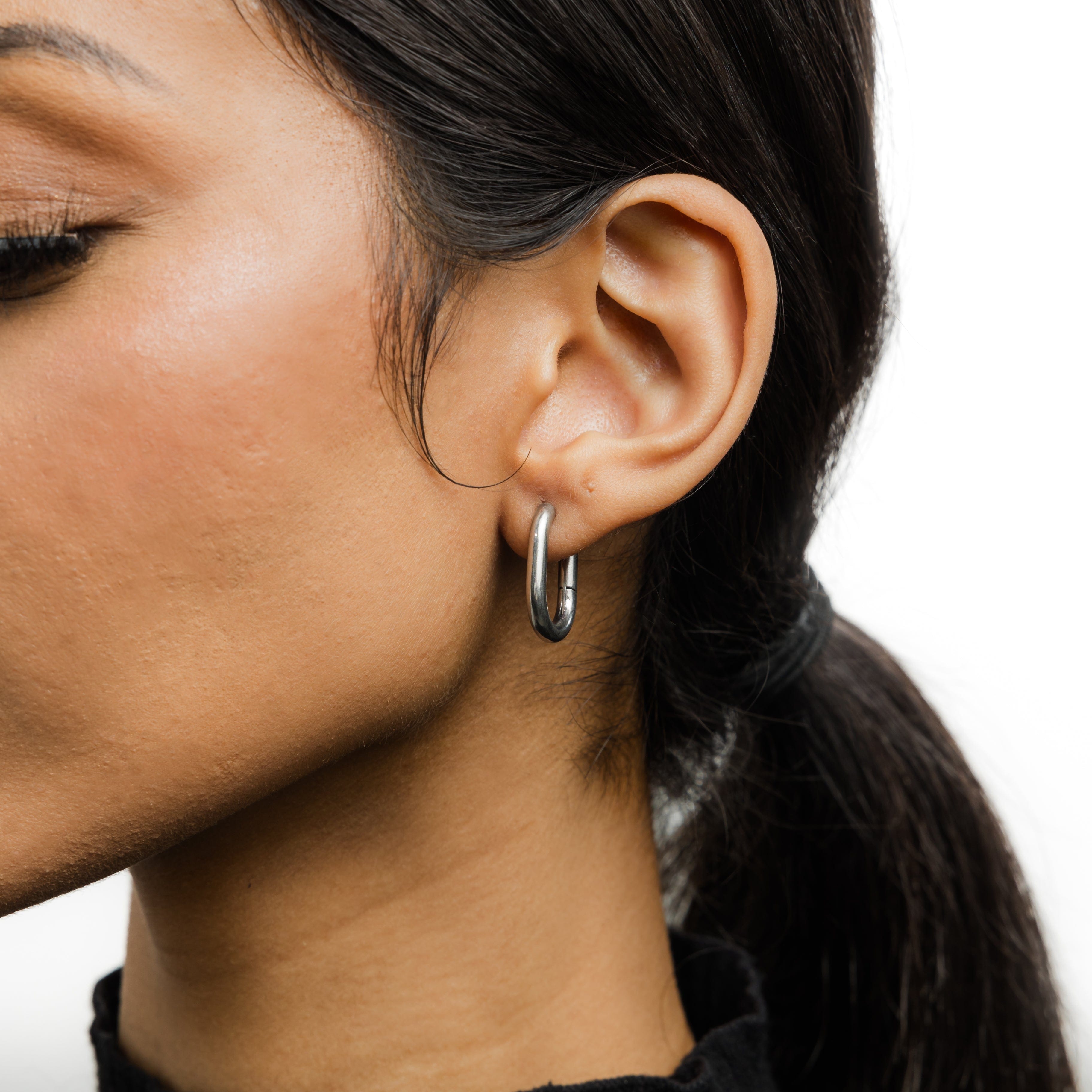 Essential Gold Oval Hoop Earrings displayed in a Nominal pouch.