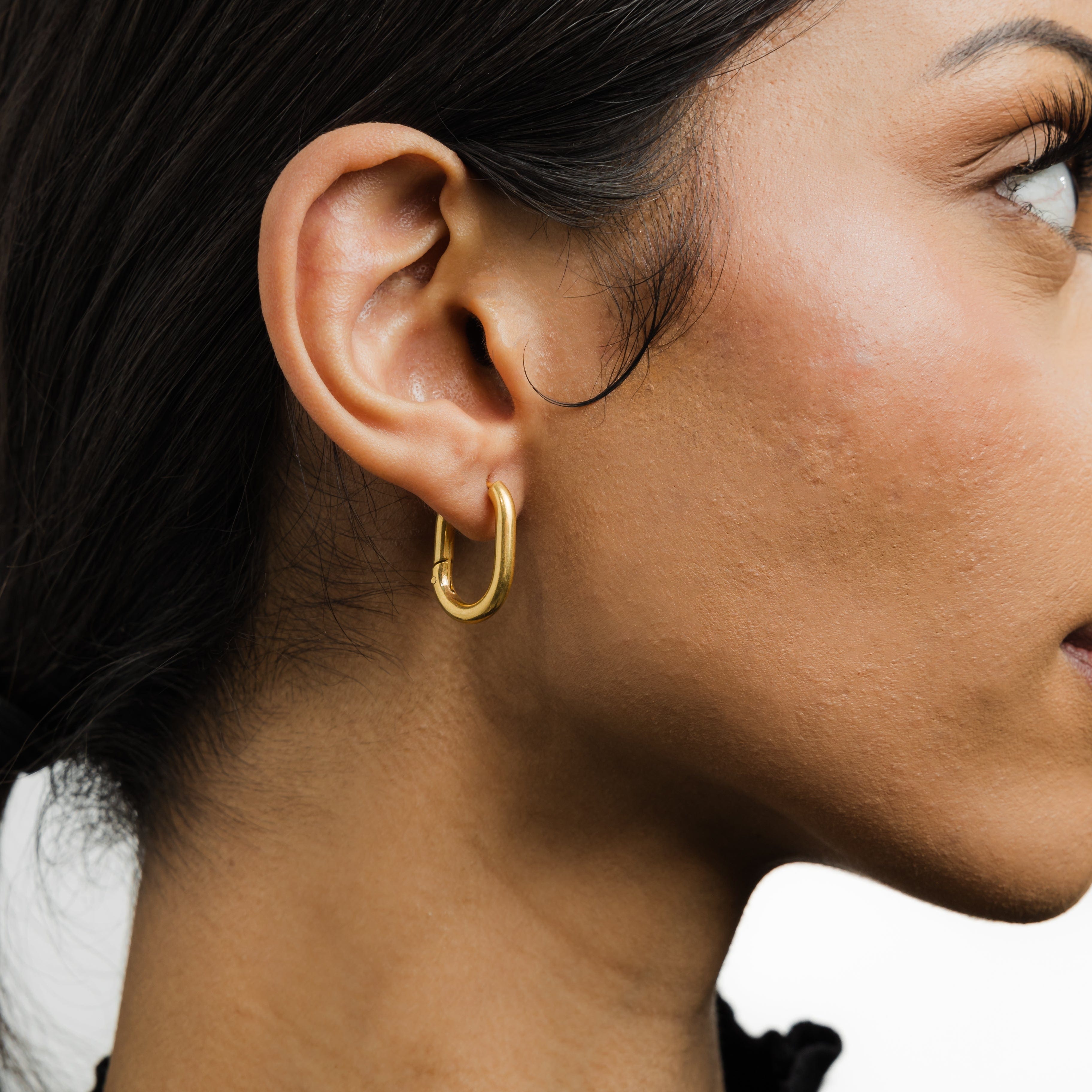 Model wearing Essential Gold Oval Hoop Earrings with a casual outfit.