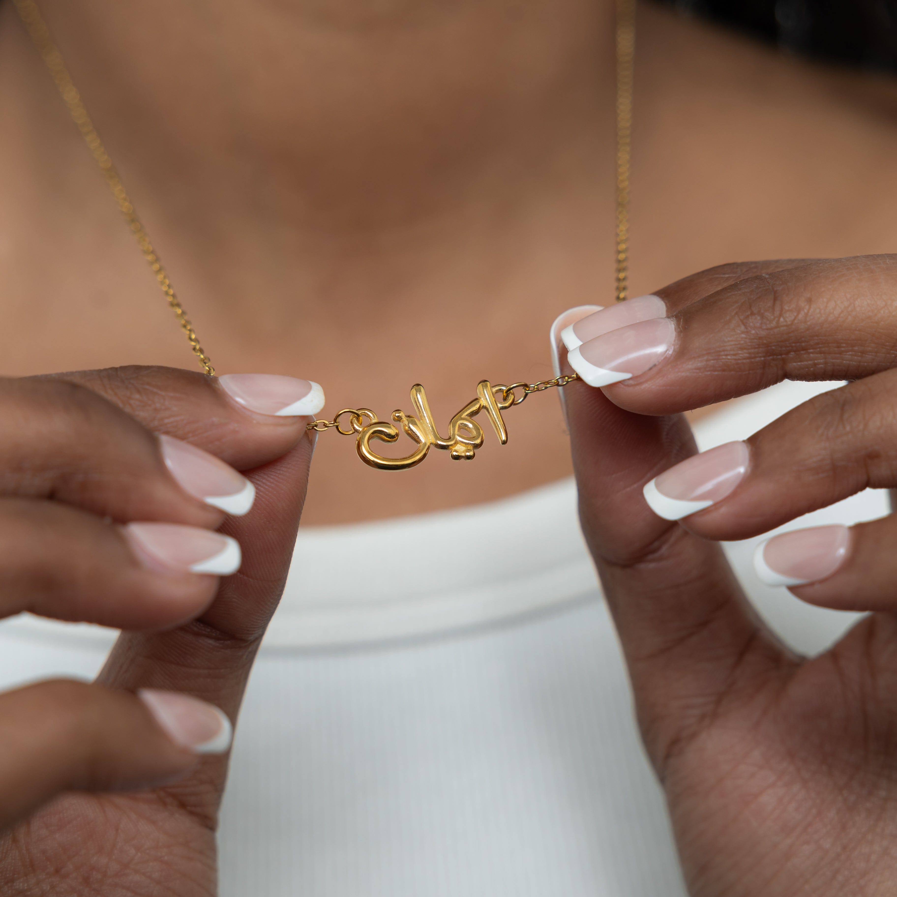 Close-up view of the gold plated faith necklace, focusing on the intricate Arabic calligraphy.
