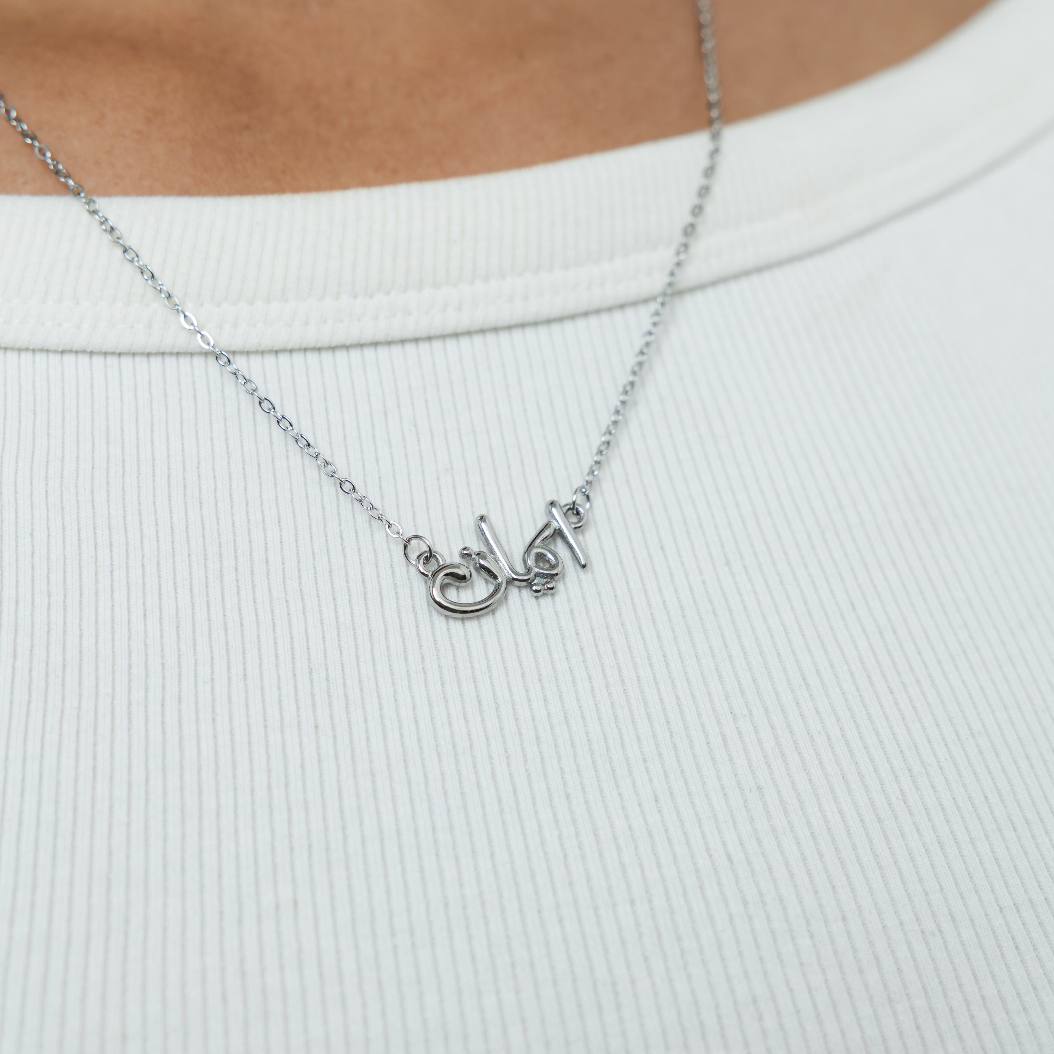 Close-up view of the gold plated faith necklace, focusing on the intricate Arabic calligraphy.