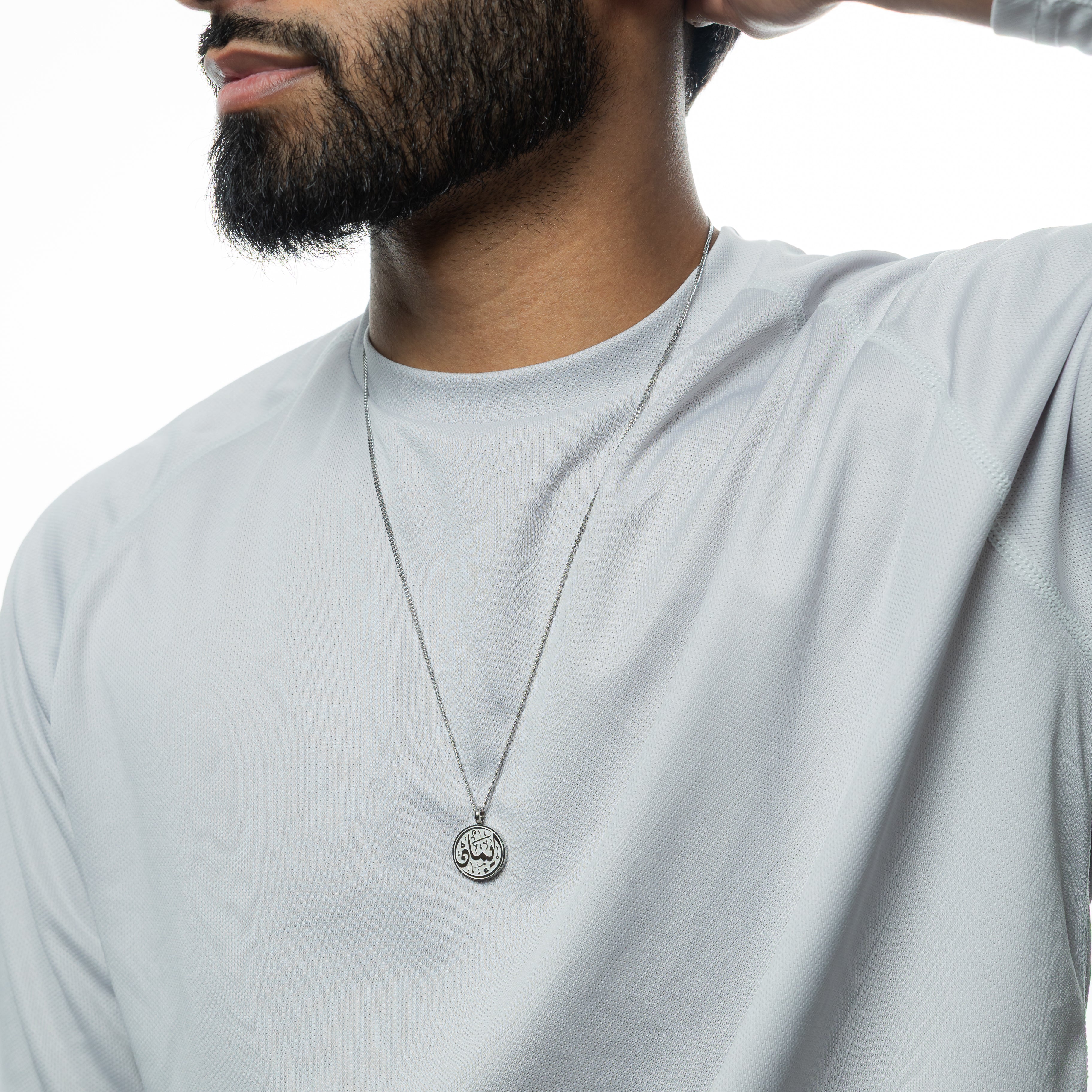 Close-up of the Iman engraved pendant necklace, highlighting the intricate calligraphy design.