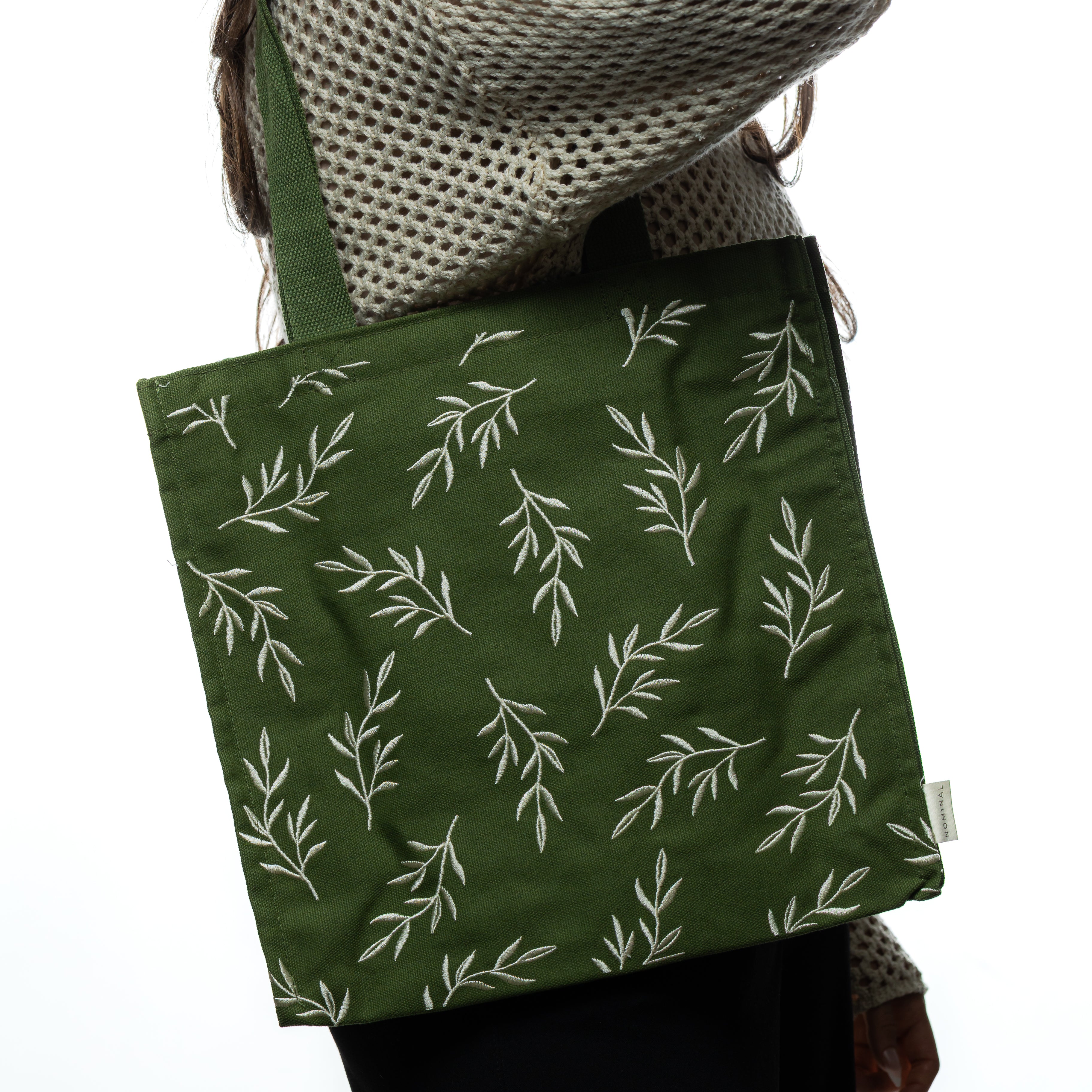 Olive Branch Freedom Tote bag displayed outdoors, emphasizing its eco-friendly canvas material.
