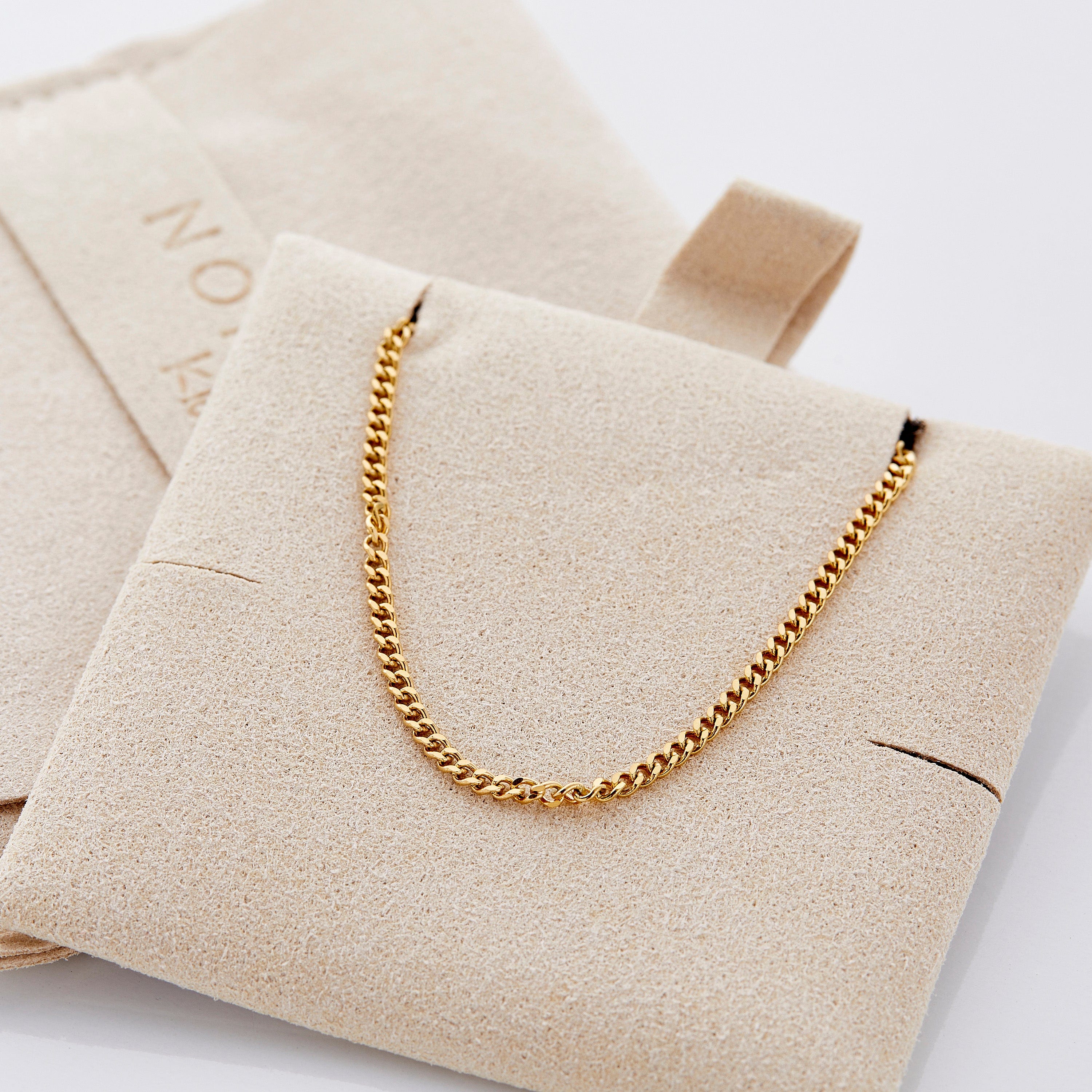Elegant presentation of the Cuban chain bracelet in a velvet drawstring pouch.