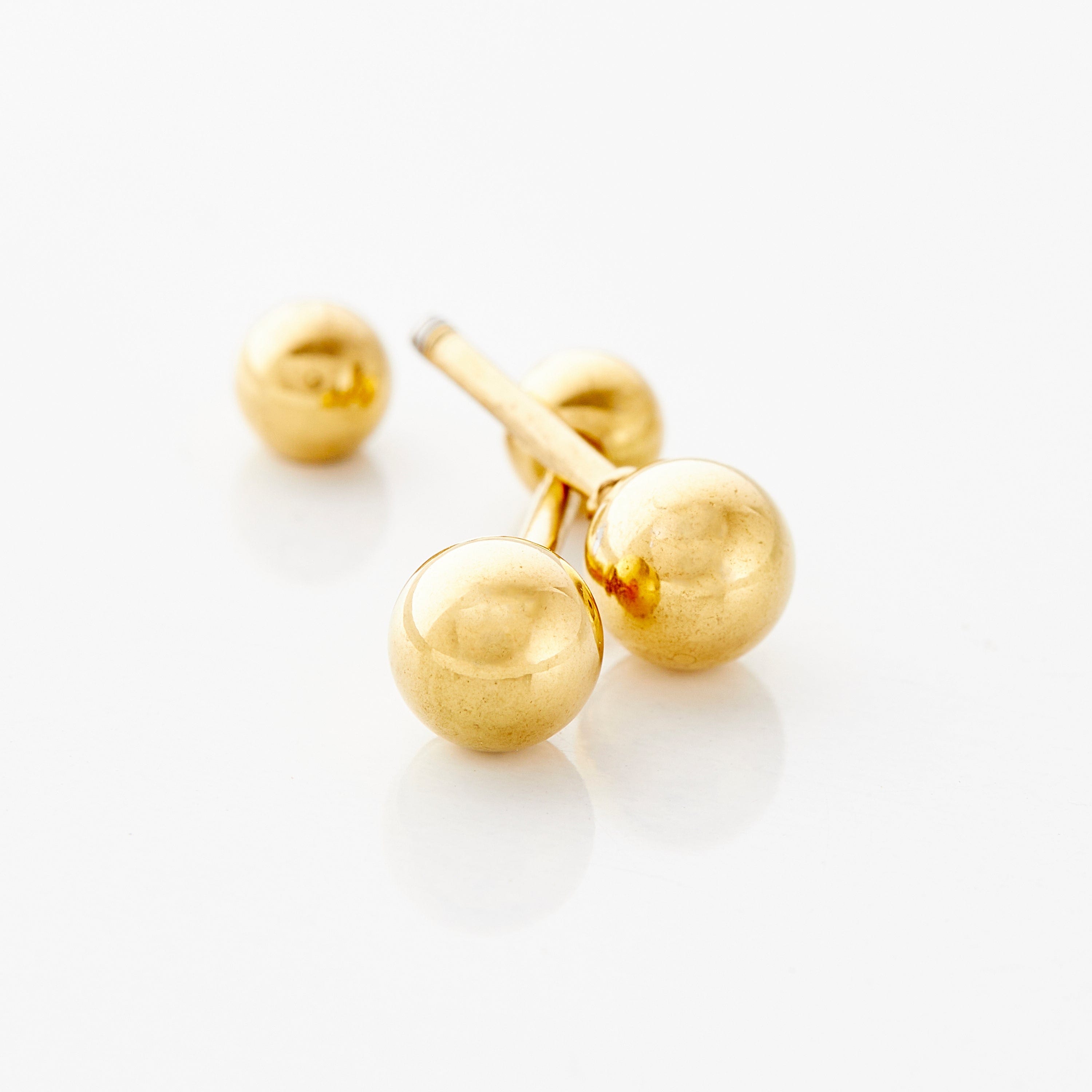 Timeless Gold Orb Earrings for kids showcased in a velvet pouch, highlighting their elegant design.