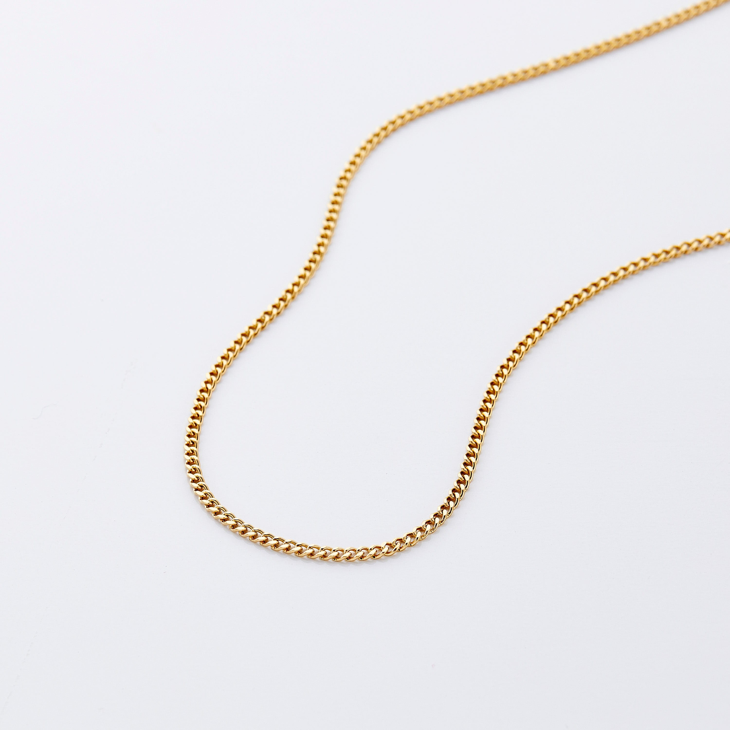 Close-up of the gold Cuban chain necklace showcasing its uniform links and shine.