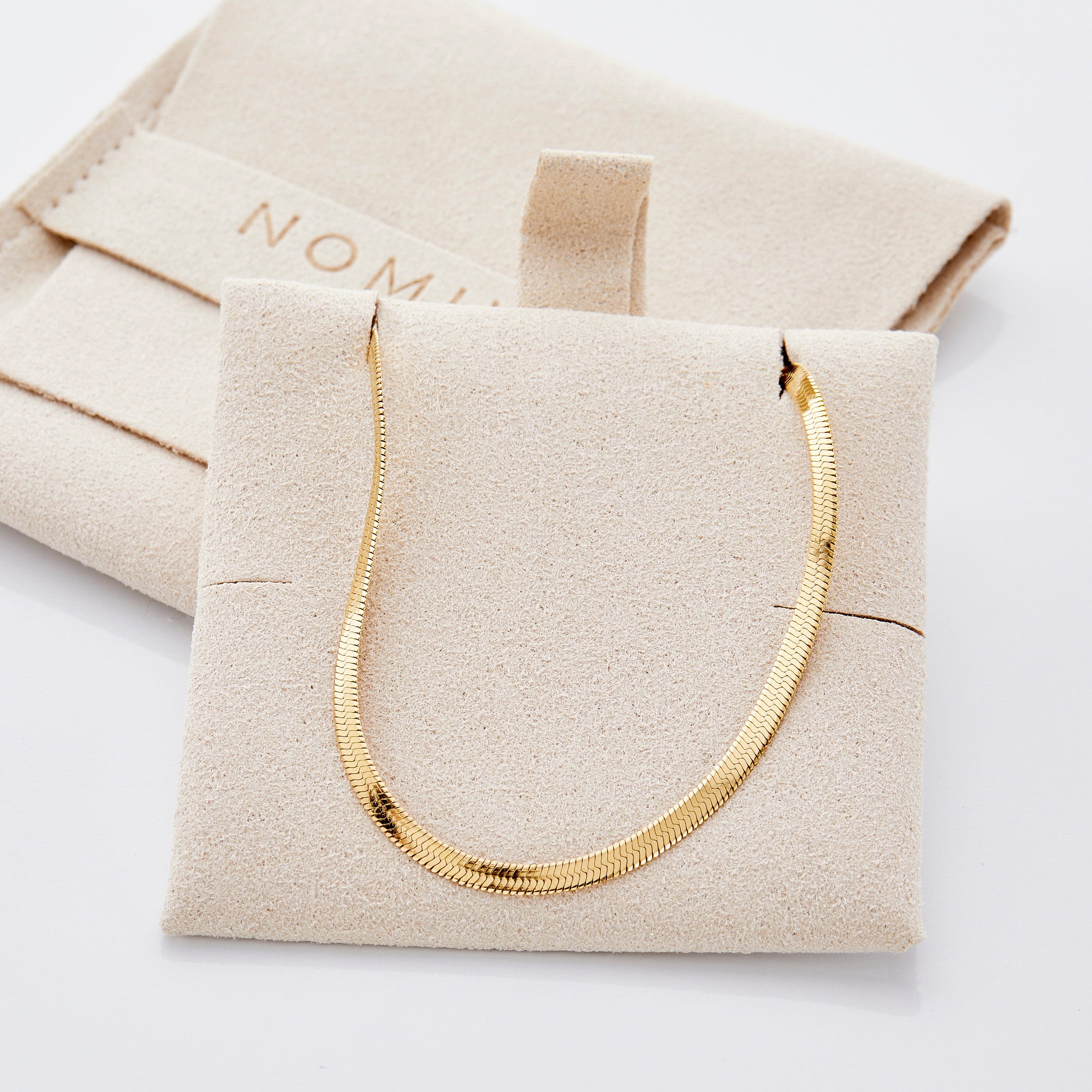 Model wearing the Liquid Gold Herringbone Necklace, showcasing its elegance in a casual setting.