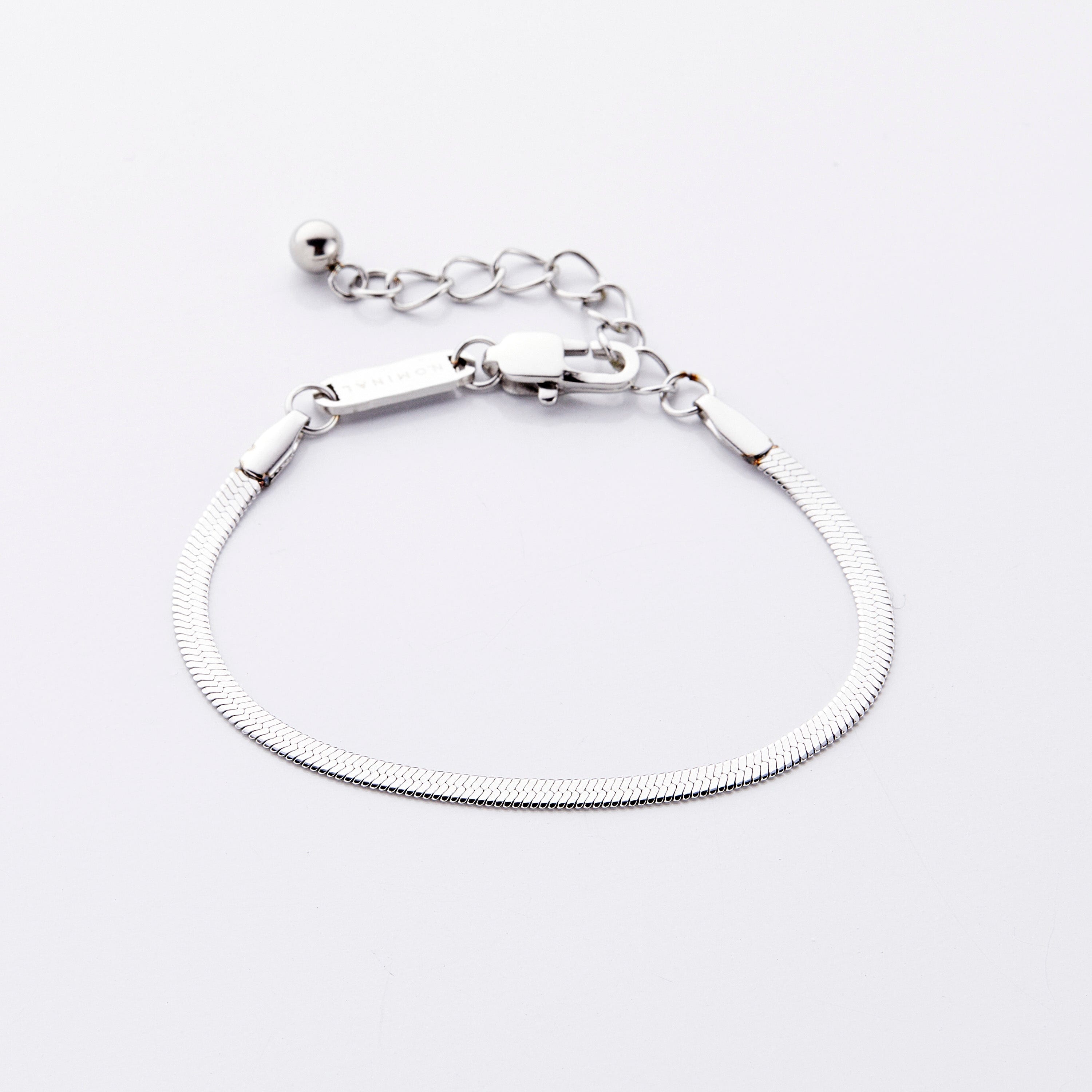 Packaged Liquid Gold Herringbone Chain Bracelet in a velvet drawstring pouch, perfect for gifting.