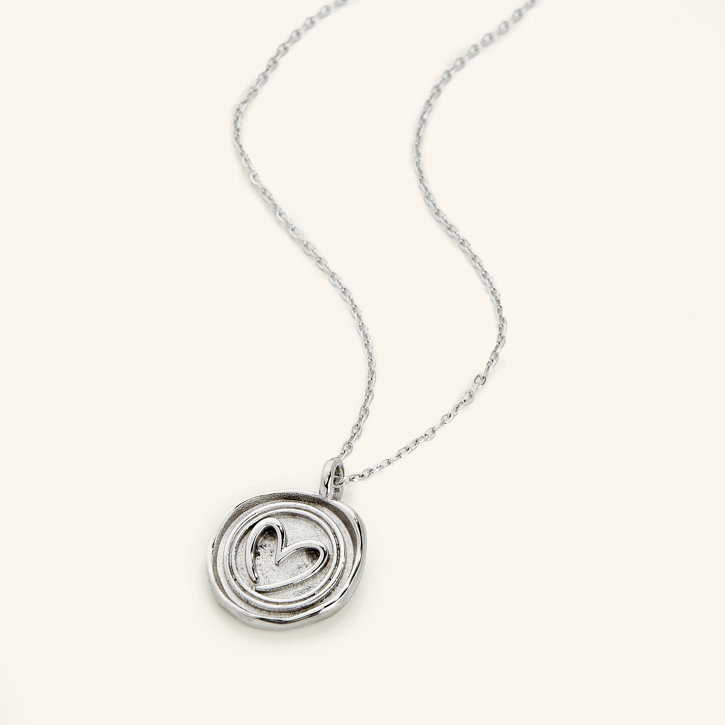 Close-up of personalized heart necklace gift in a velvet pouch.