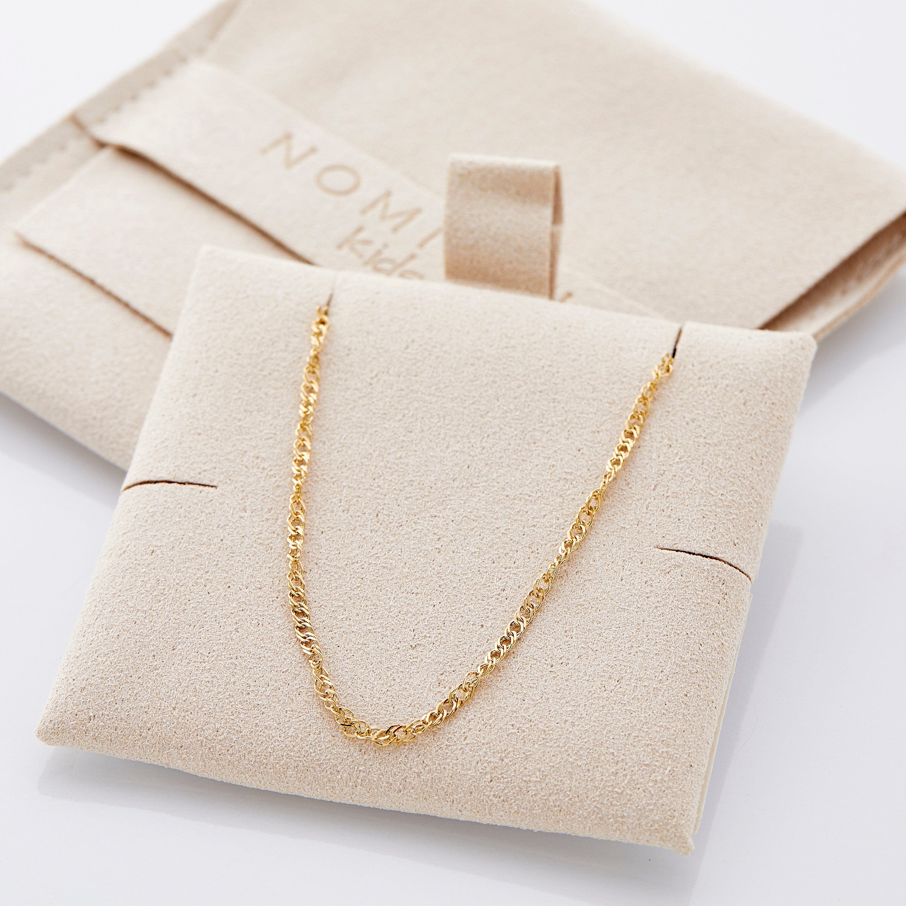 A little girl wearing the twisted chain necklace, radiating confidence at a birthday party.