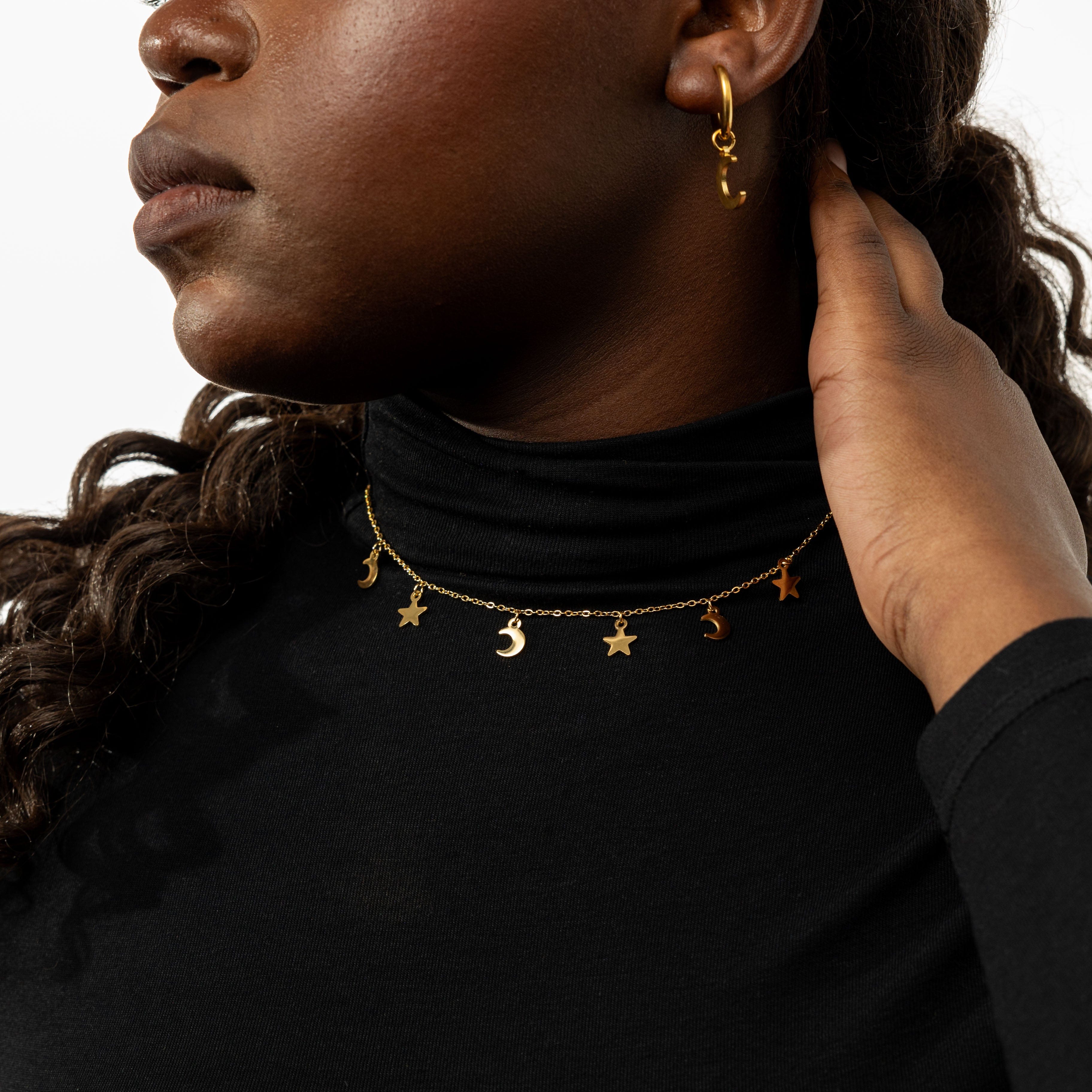 Close-up of the gold choker necklace displaying the intricate star charm design.