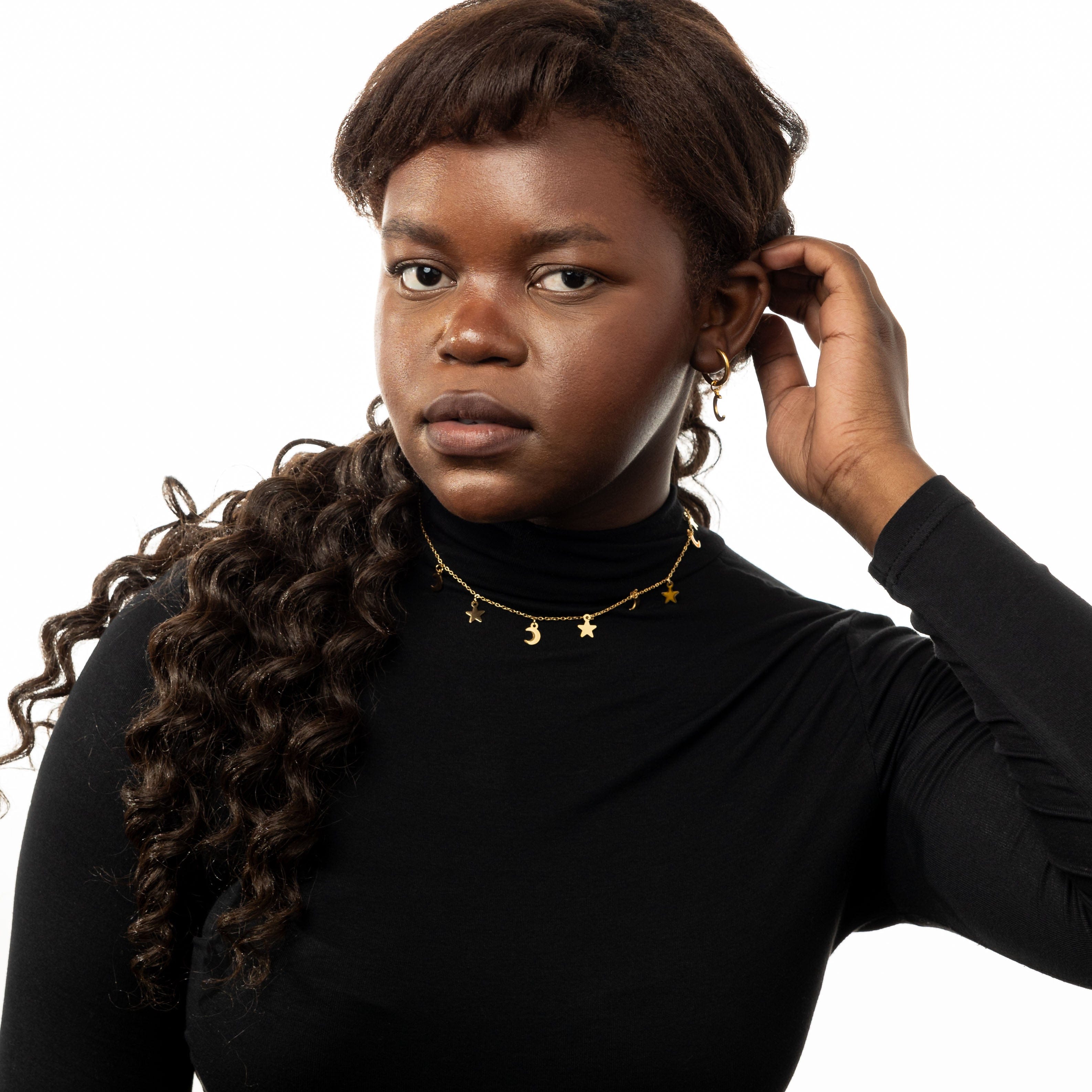 Celestial Charm Layered Choker Necklace laid flat on a velvet pouch, highlighting its shiny finish.