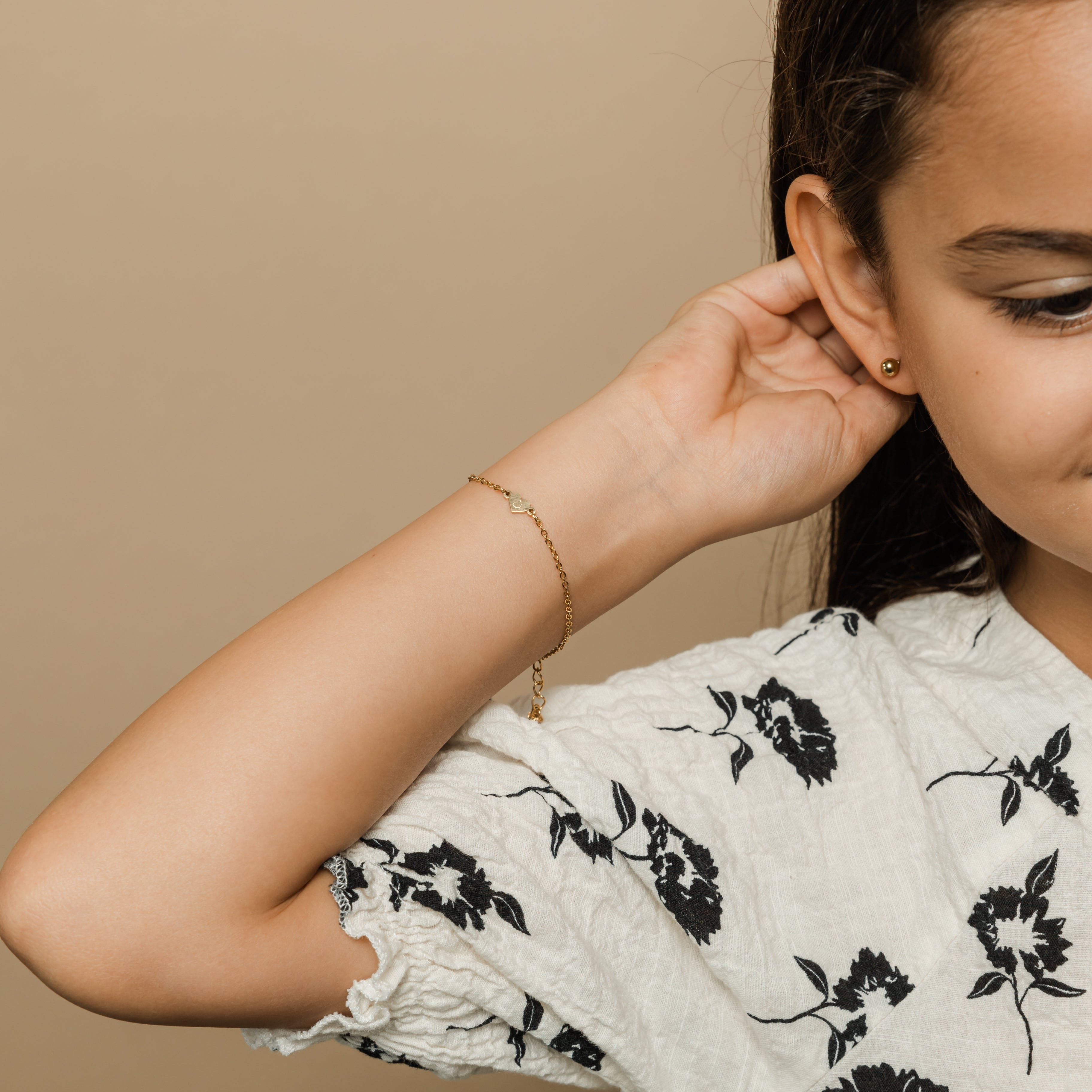 A little girl happily wearing her custom name bracelet, perfect for sensitive skin.