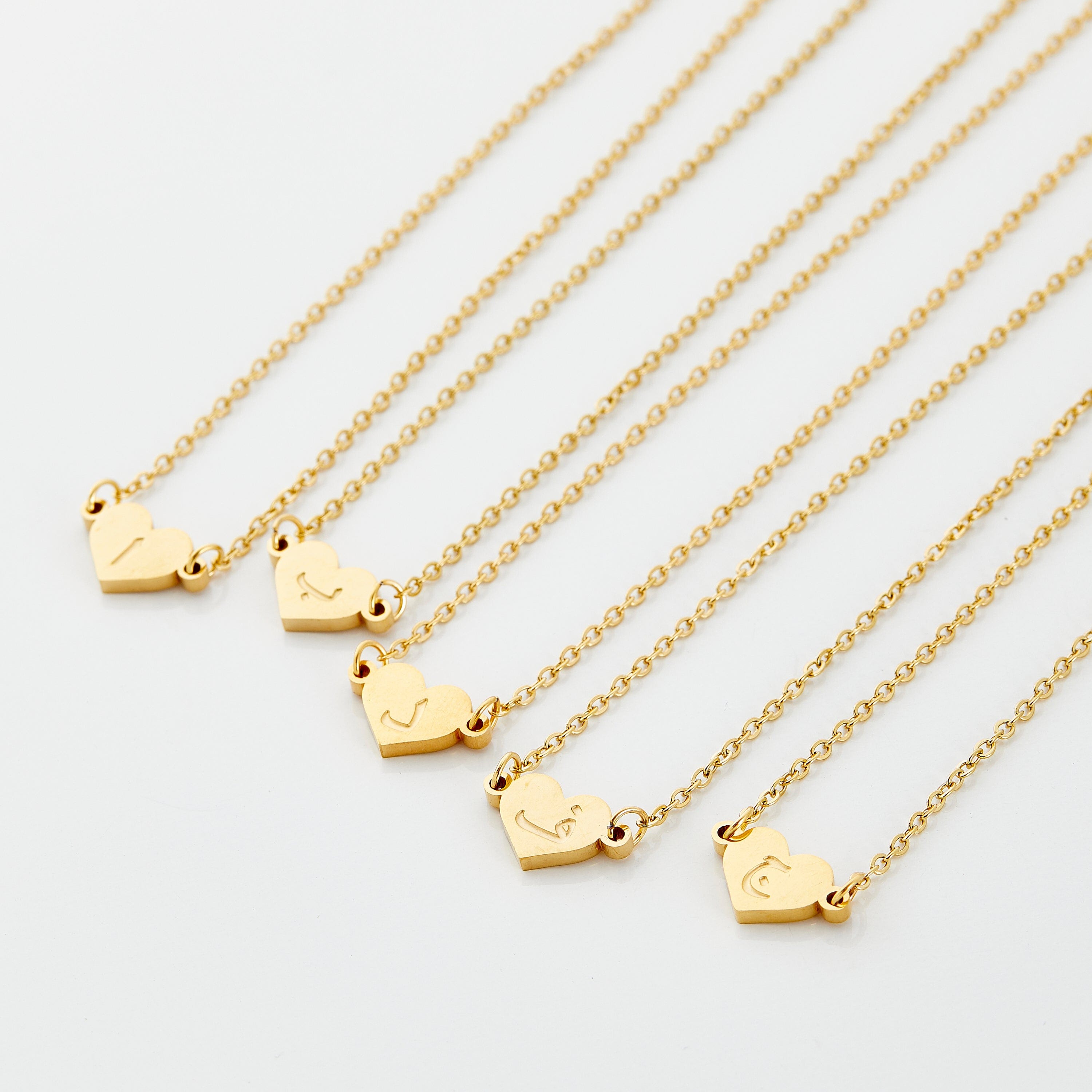 Close-up view of the personalized Arabic letter heart necklace, showcasing its elegant gold finish.