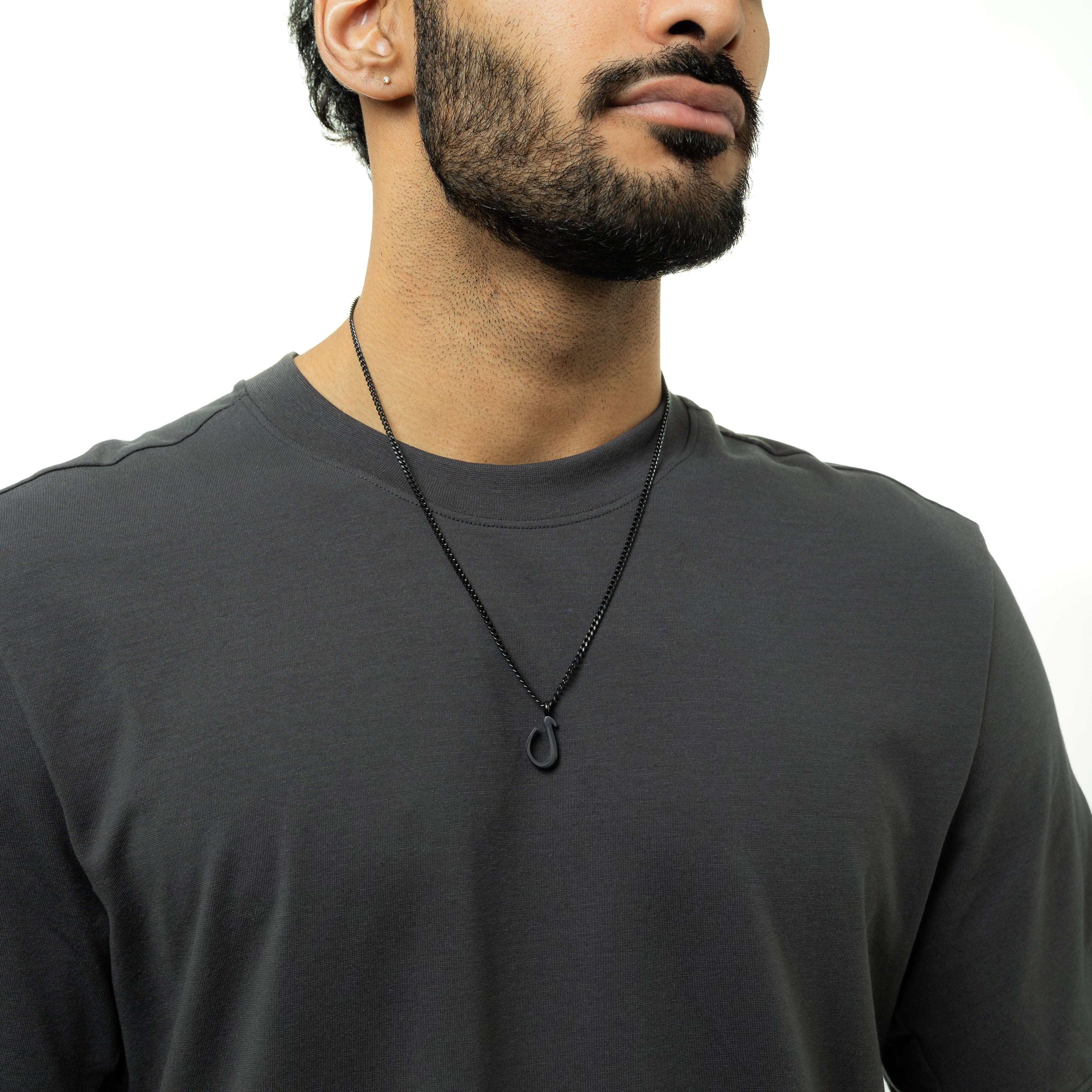 Close-up of the Arabic letter necklace on a model, showcasing its elegant design and curb chain.