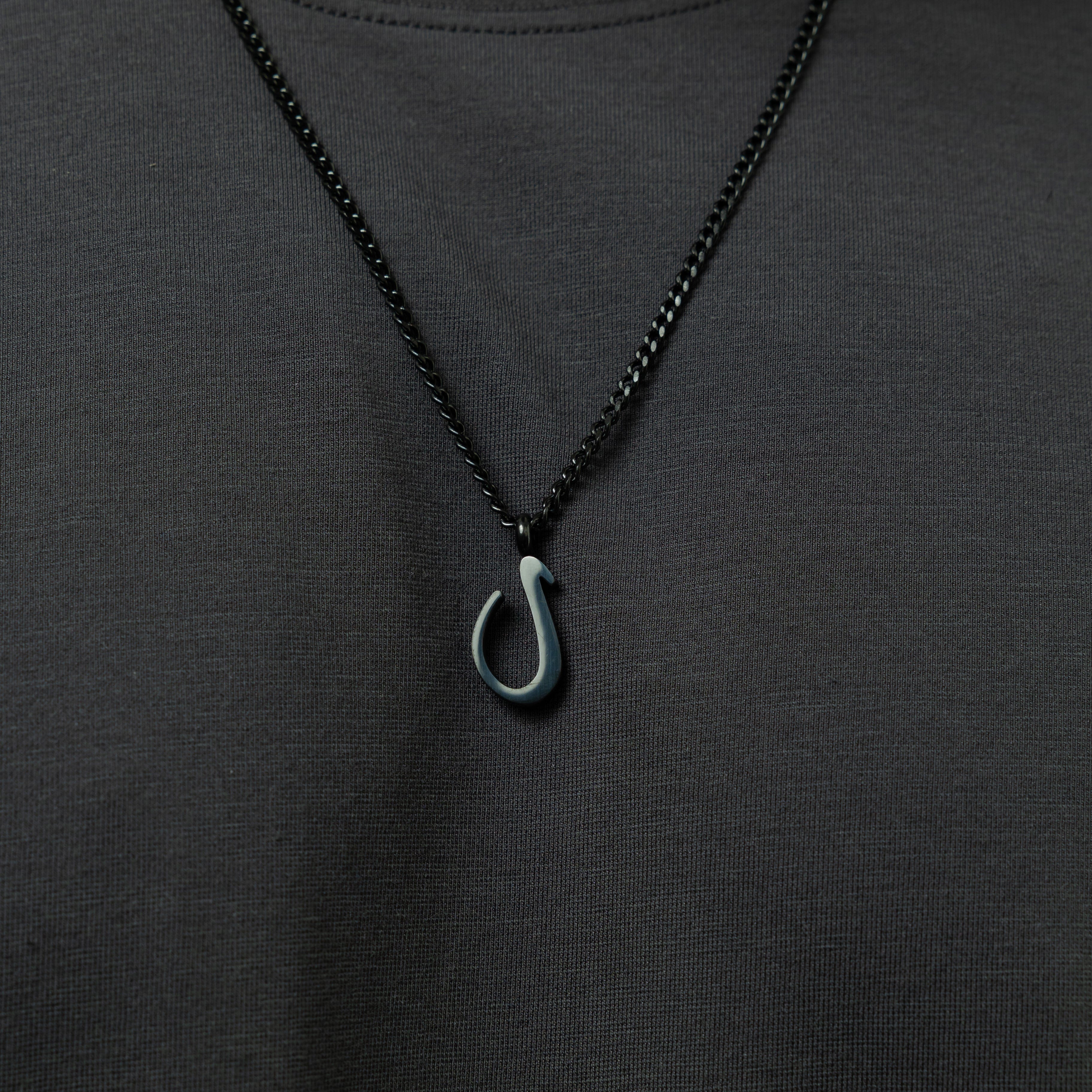 The Arabic letter necklace displayed in a velvet pouch, highlighting its premium quality and packaging.