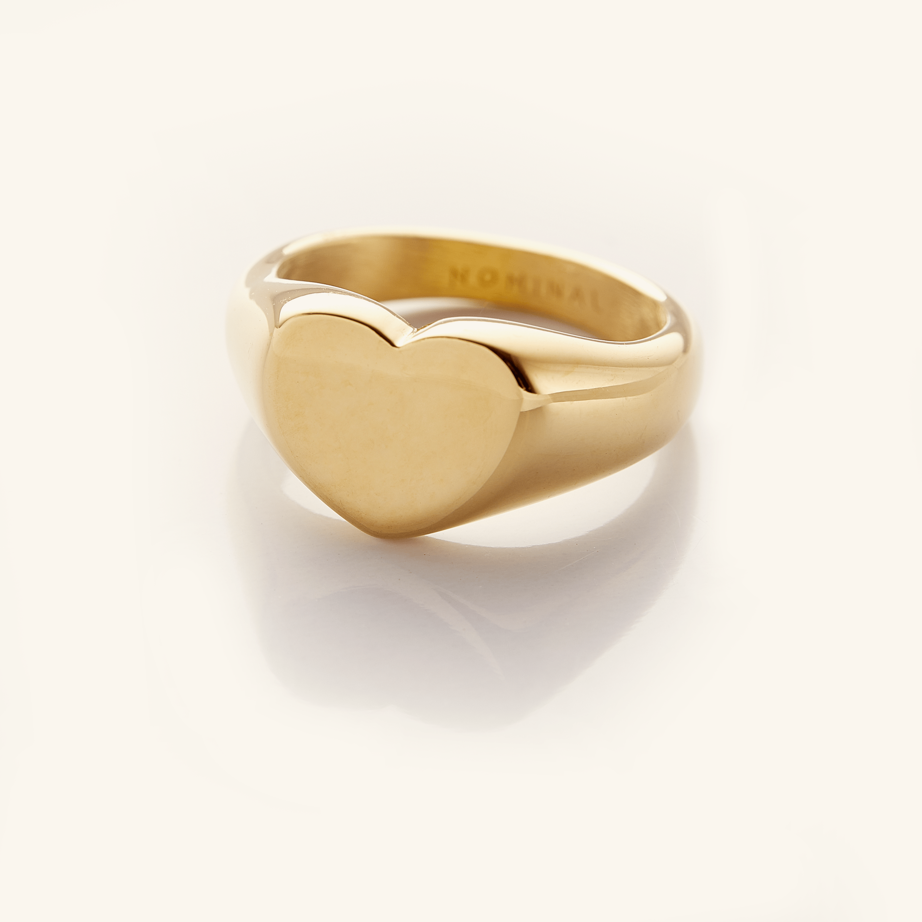 Timeless Love Heart Signet Ring displayed at an angle, showcasing its flat heart top and gold finish.