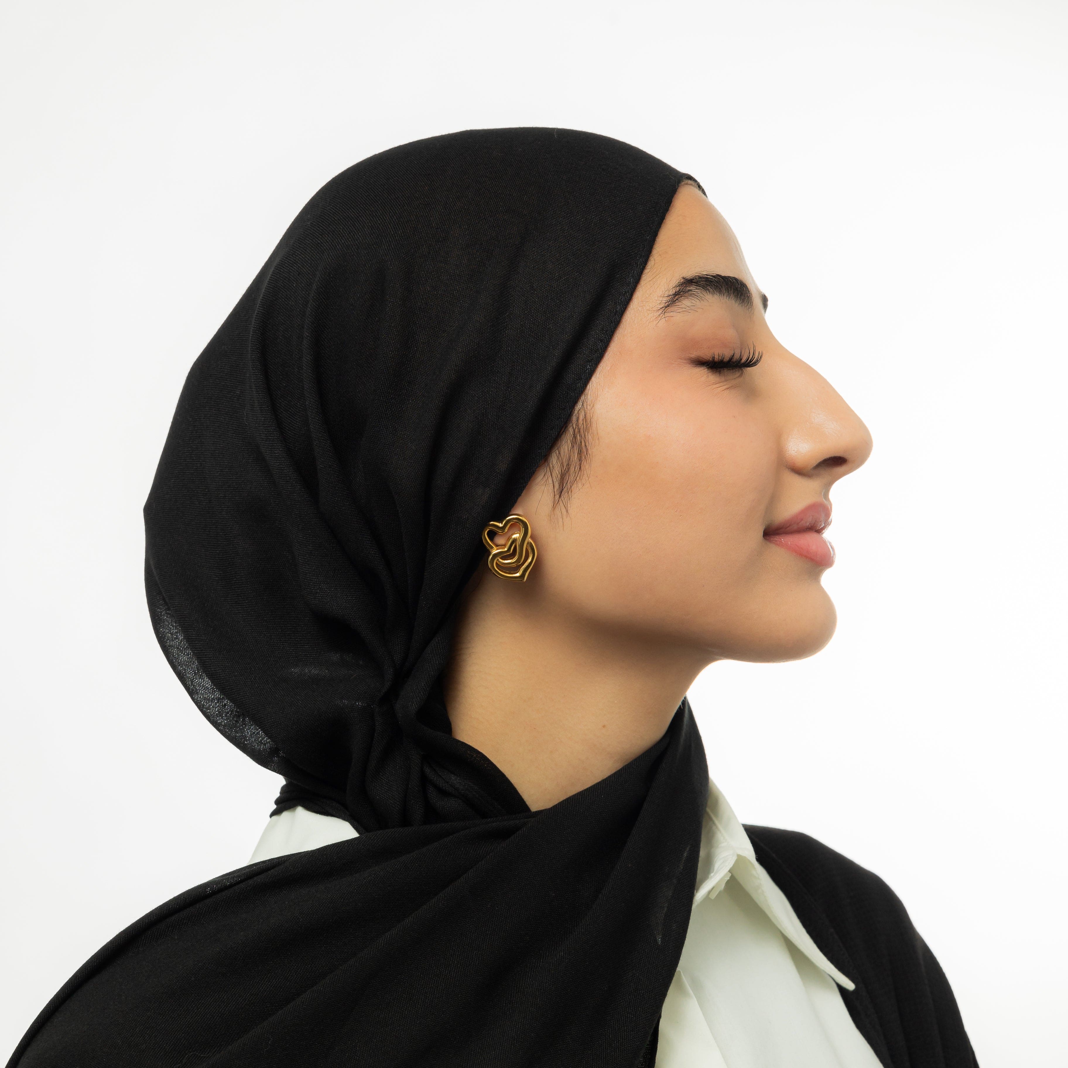 Close-up of LoveFusion Statement Earrings showing intricate heart design and gold finish.