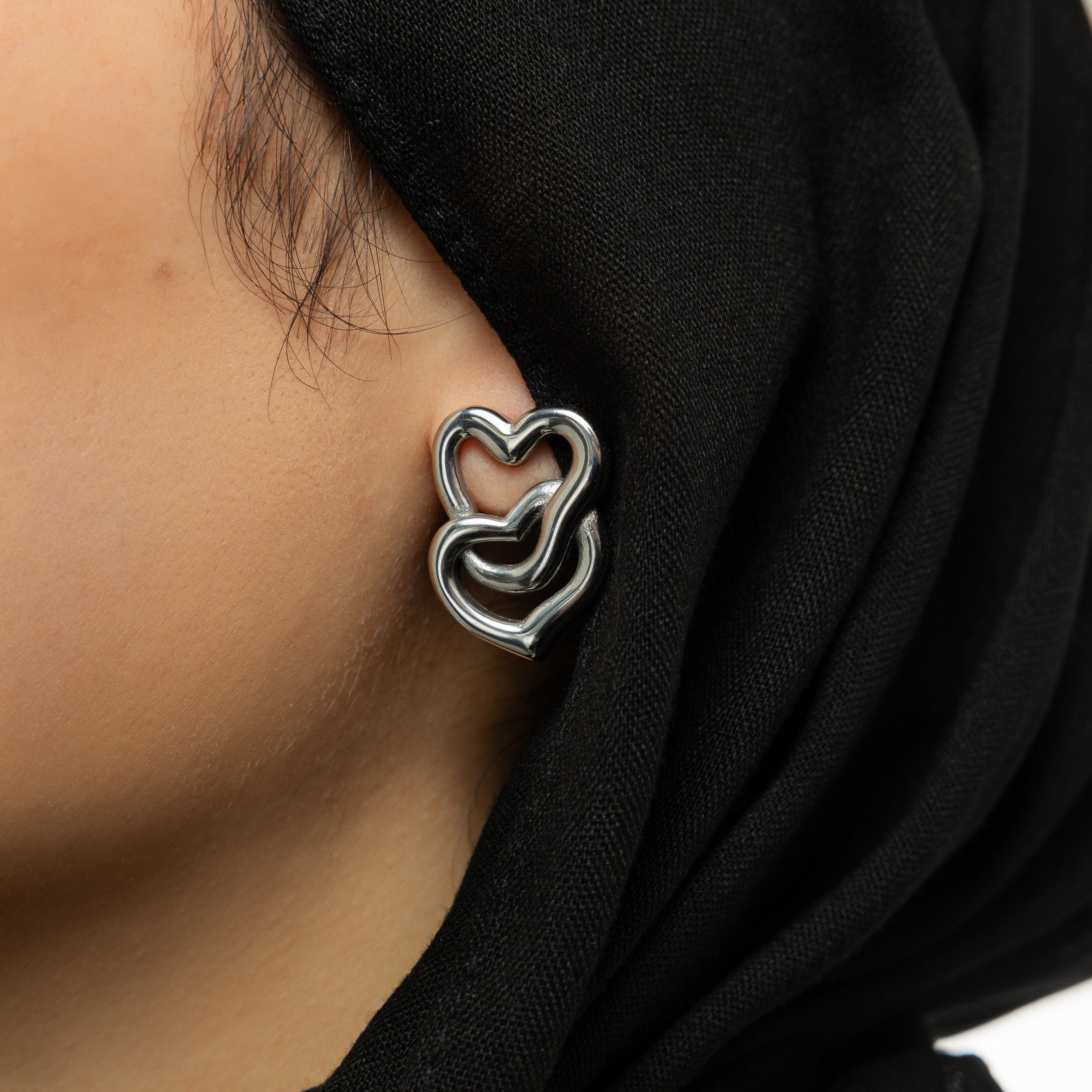 Close-up of LoveFusion Statement Earrings showing intricate heart design and gold finish.