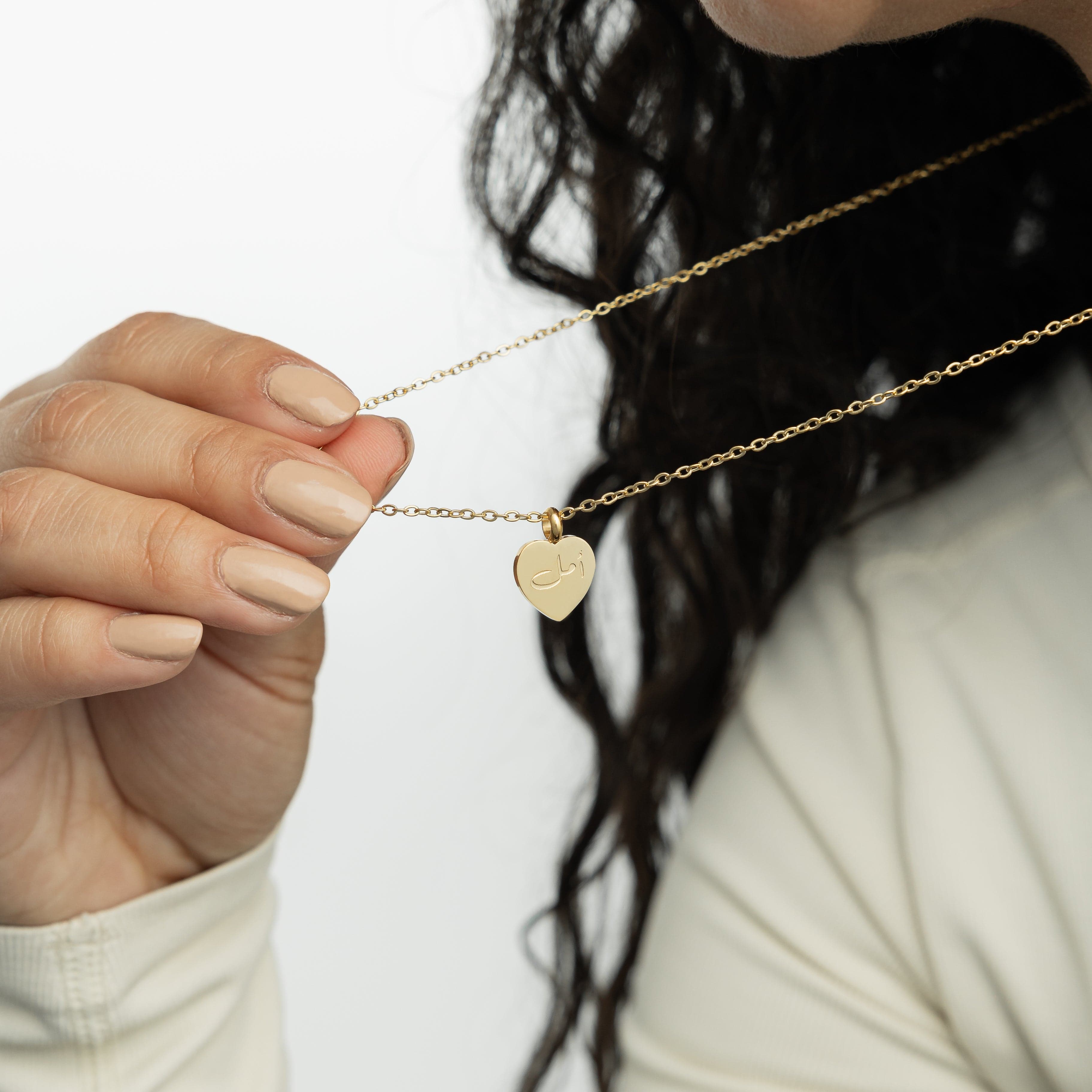 The gold necklace with a hope pendant, highlighting the hypoallergenic features for sensitive skin.