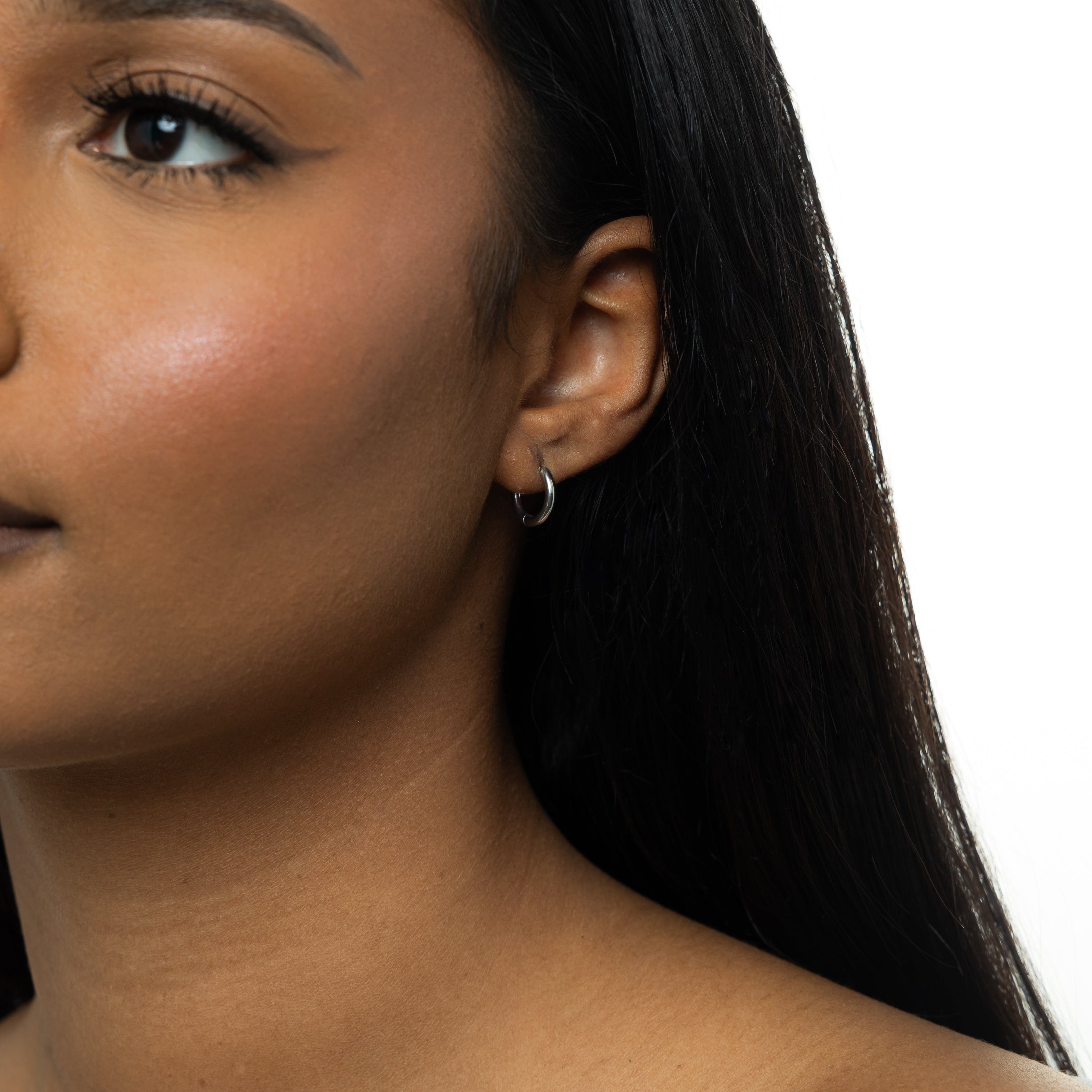 Waterproof gold huggie earrings for women displayed on a clean, minimalist background to emphasize their elegant, small hoop design.
