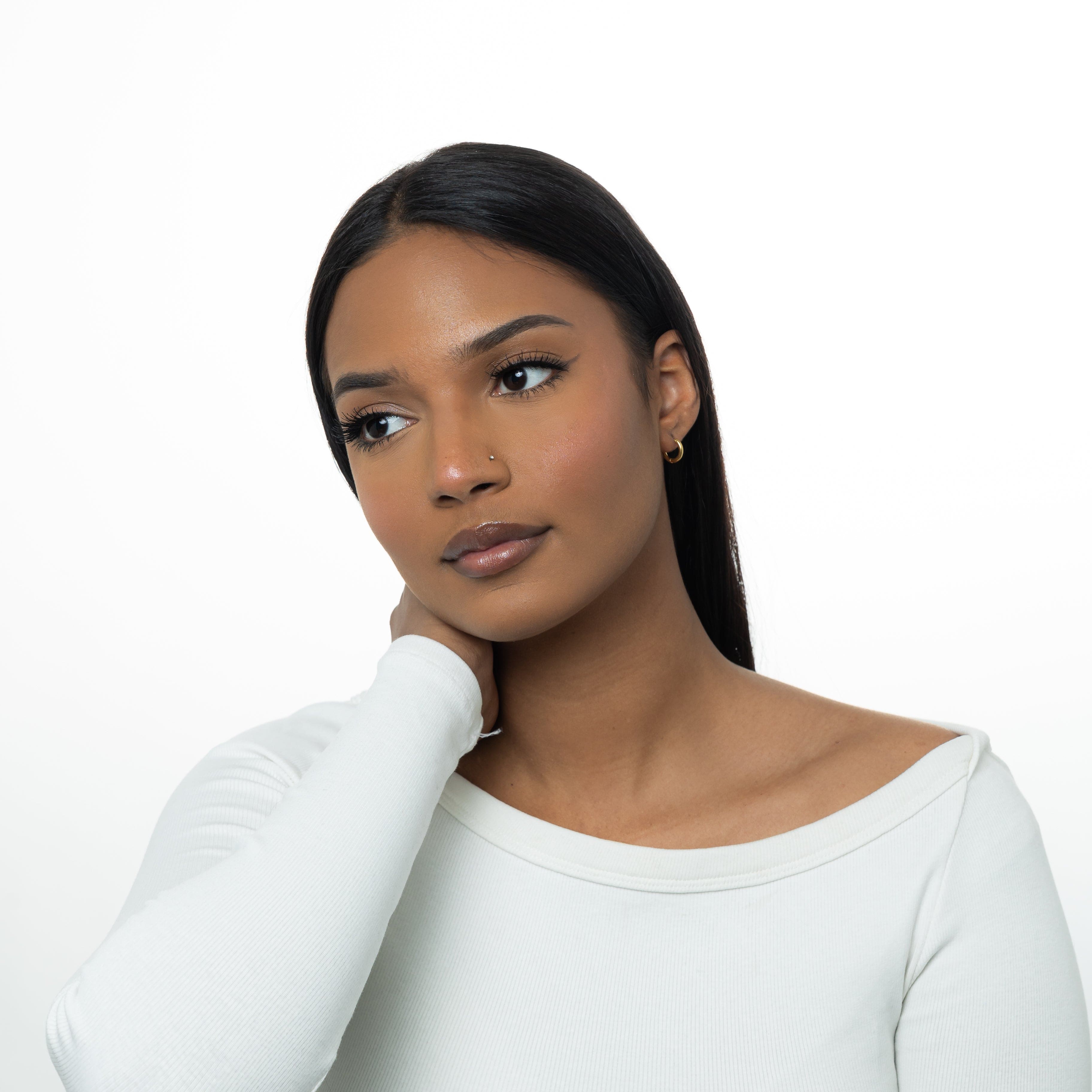 Lifestyle shot of the best 8mm gold huggie earrings worn in a casual setting, highlighting their perfect fit for sensitive ears.