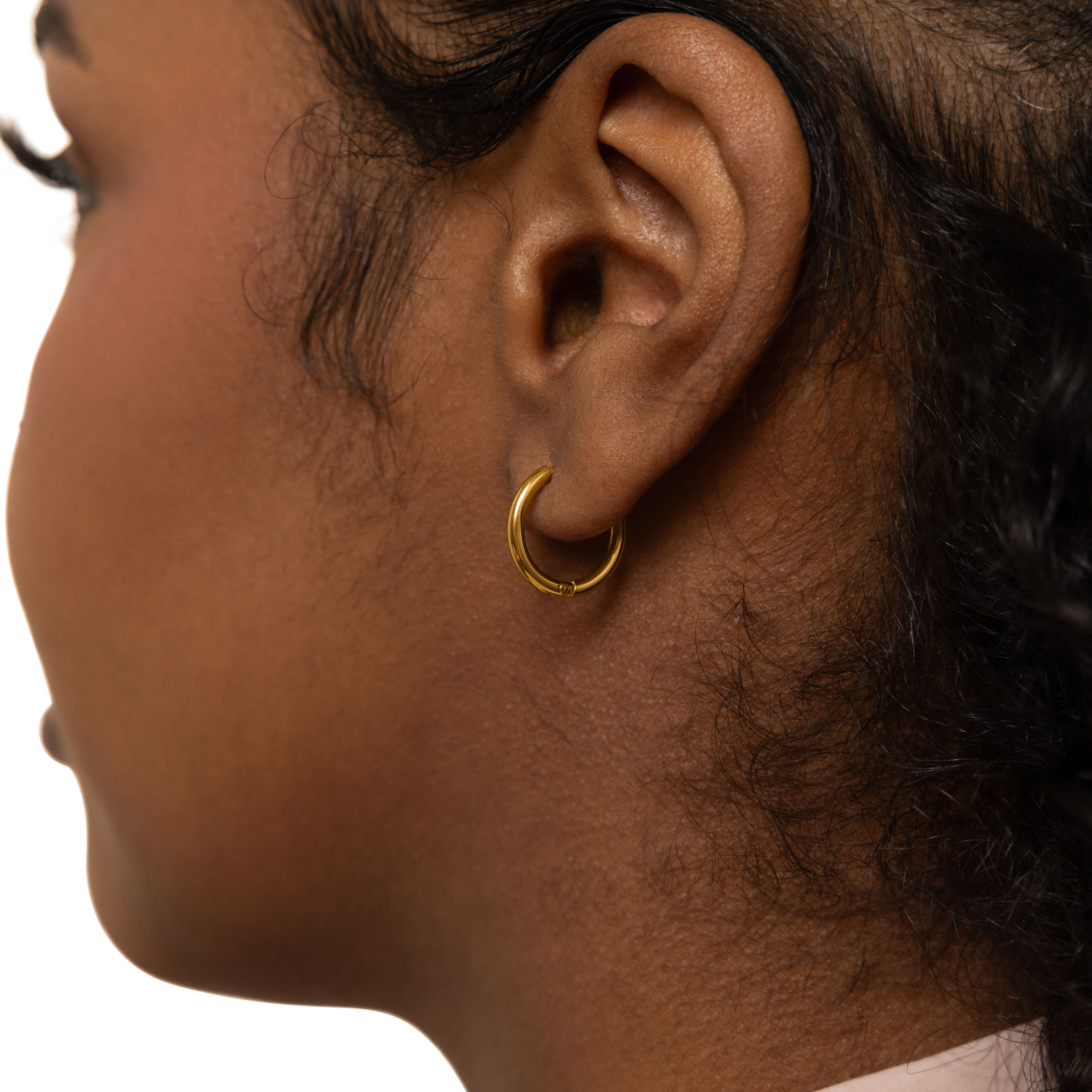 Close-up view of the small gold hoop earrings highlighting their 18K gold plating and shiny finish.