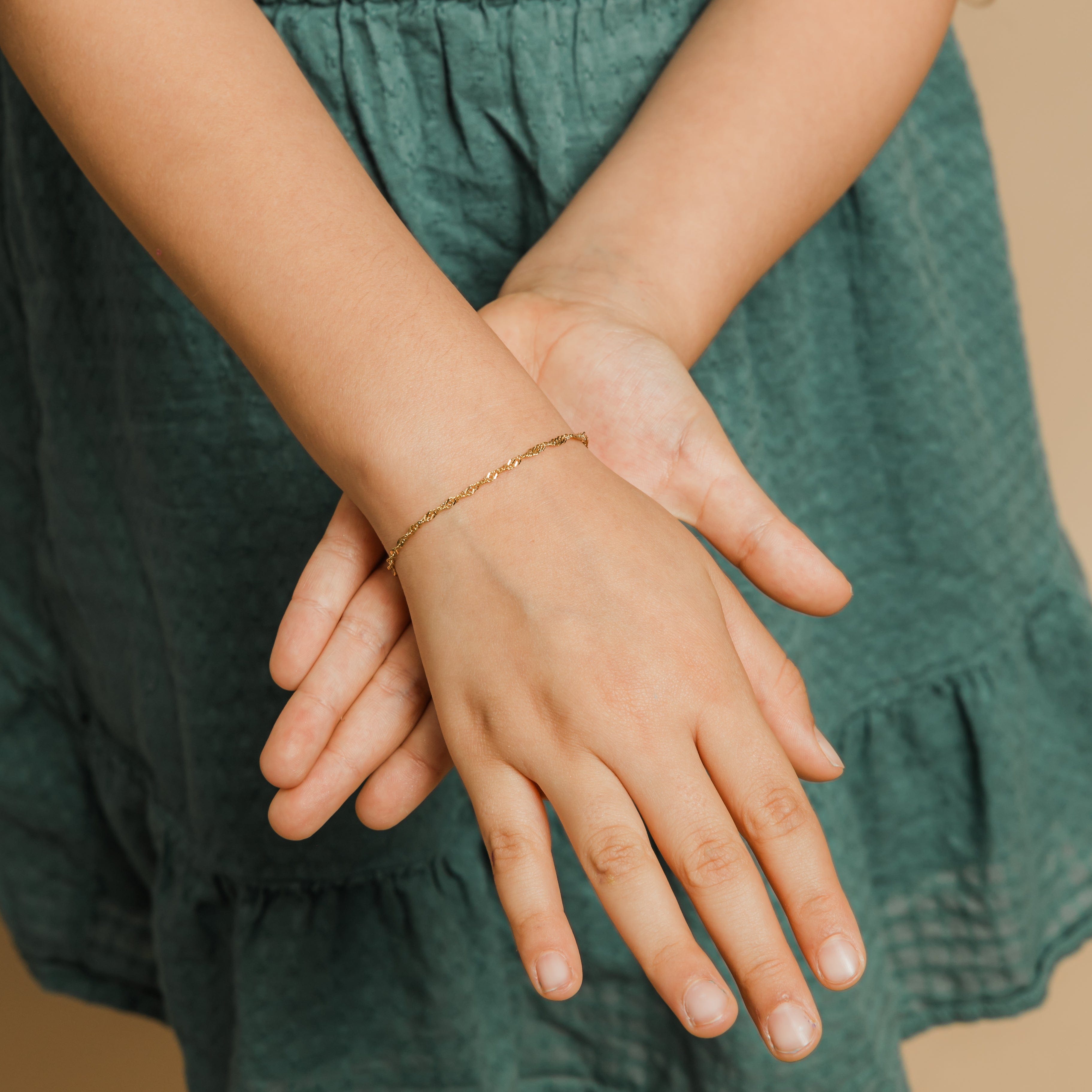 A young girl wearing the hypoallergenic bracelet, smiling confidently at a sunny outdoor event.