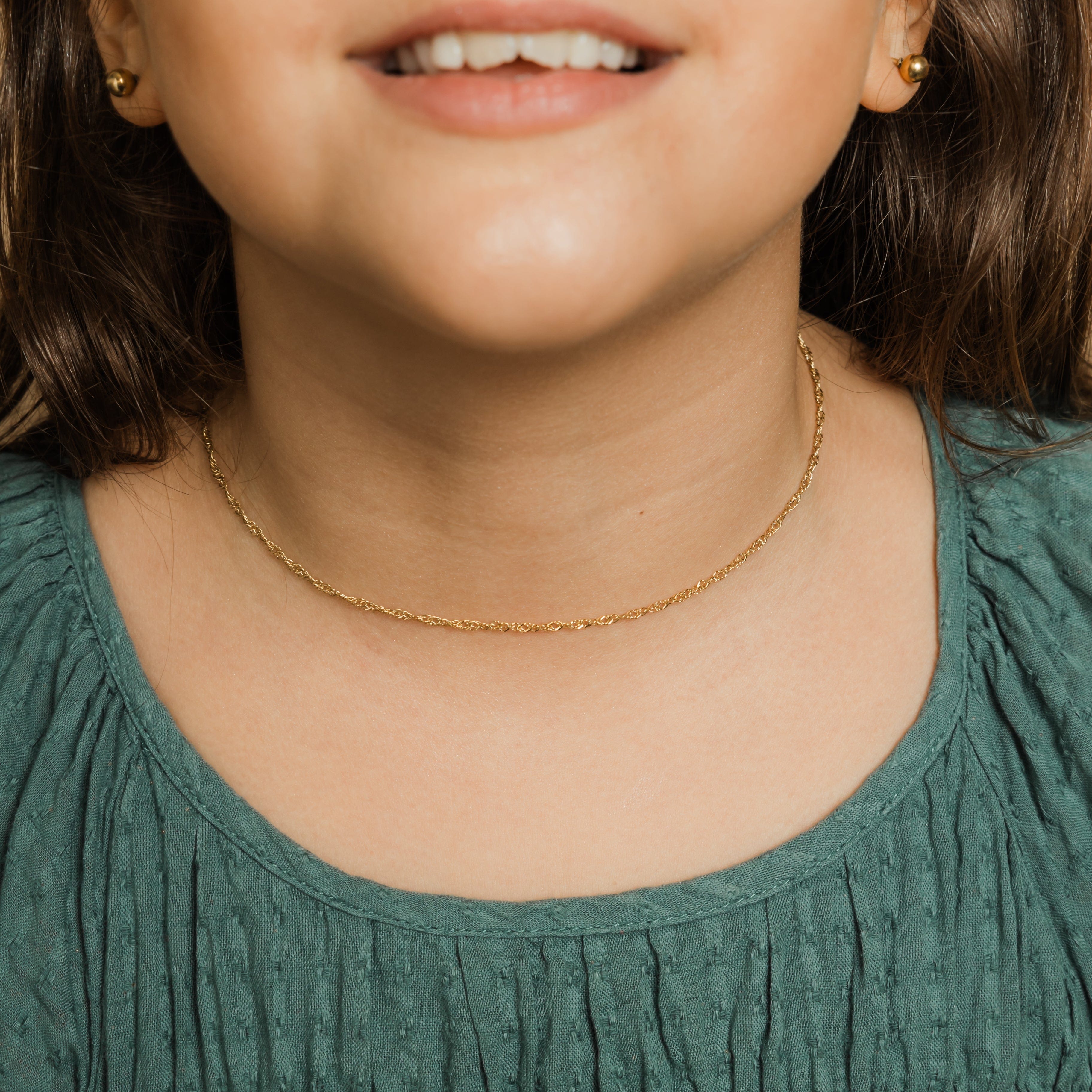 Close-up of the girls twisted chain necklace, emphasizing the premium 18k gold plating.