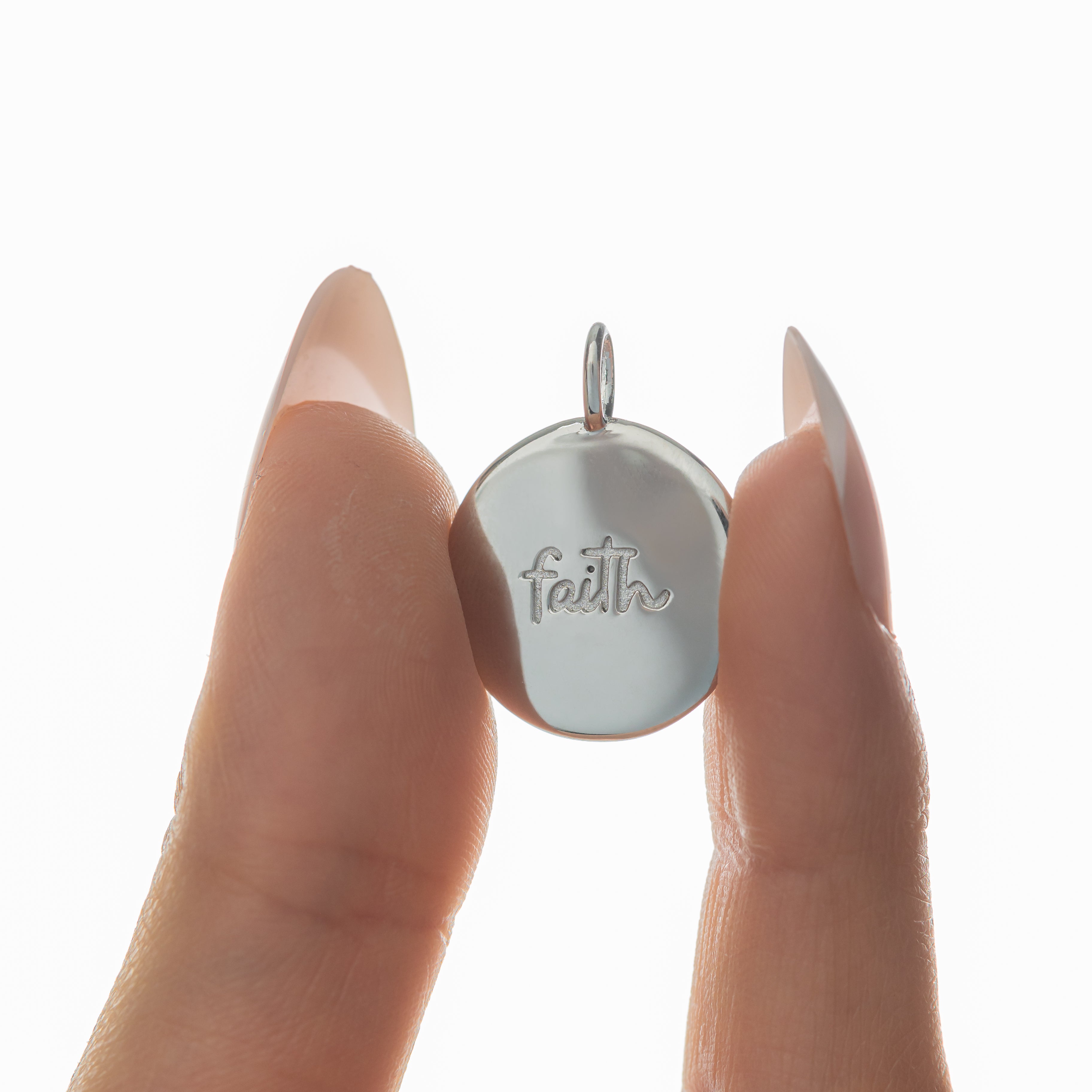 Close-up of the Iman Faith Charm highlighting its Arabic engraving and gold finish.