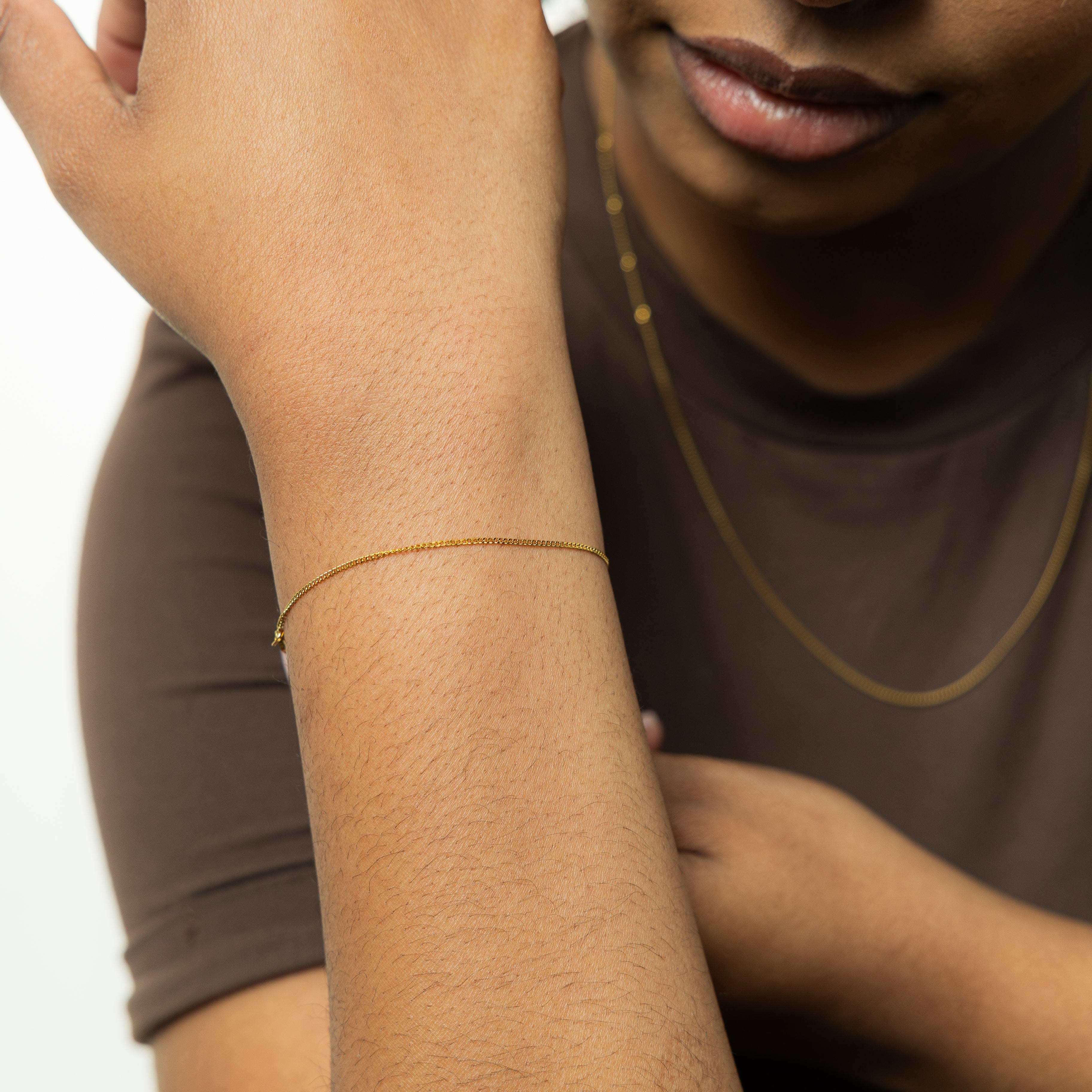 Model wearing the Invisible Curb Gold Bracelet at a party, highlighting its suitability as affordable statement jewelry.