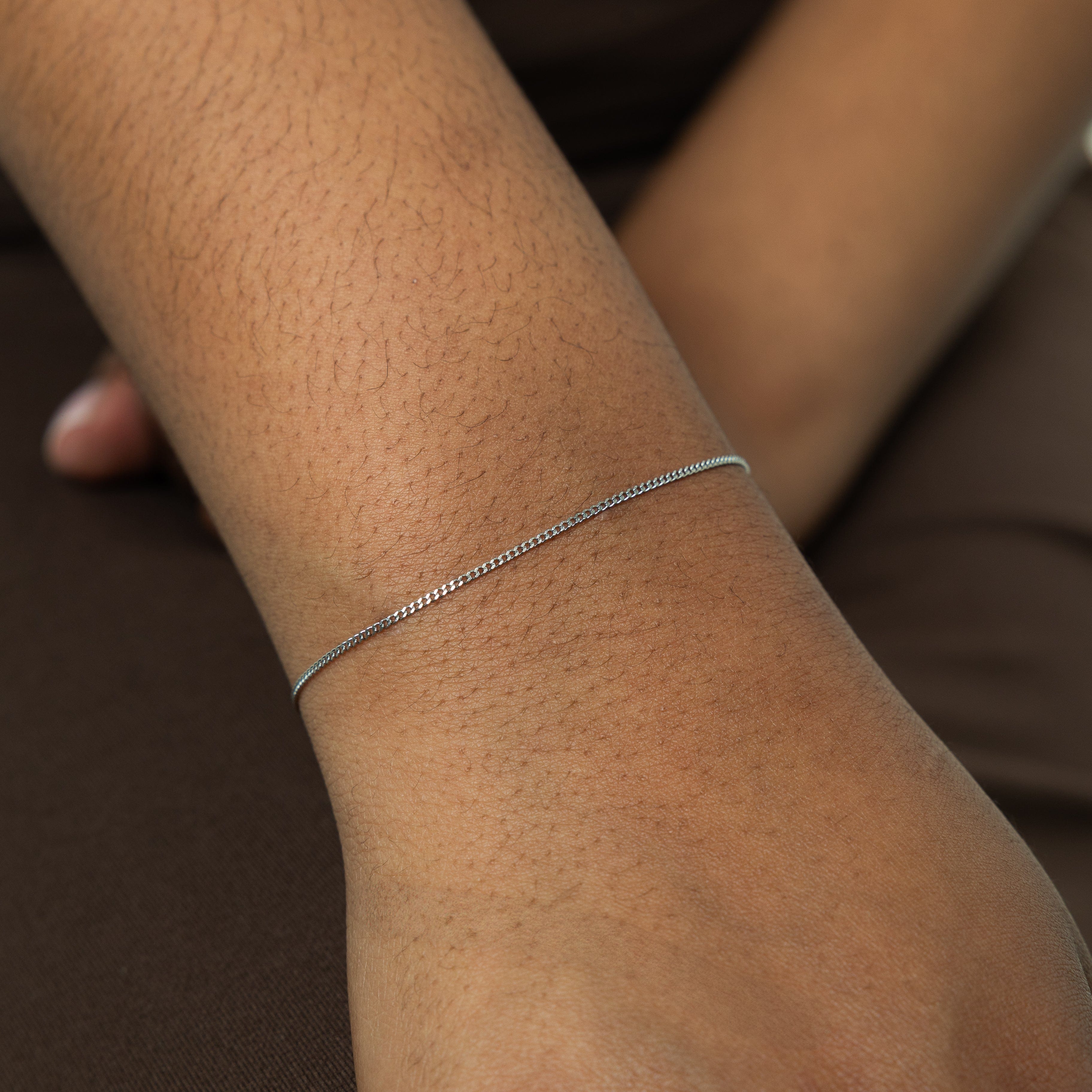 Elegant packaging of the Invisible Curb Gold Bracelet in a soft velvet pouch, emphasizing its gift-ready quality.