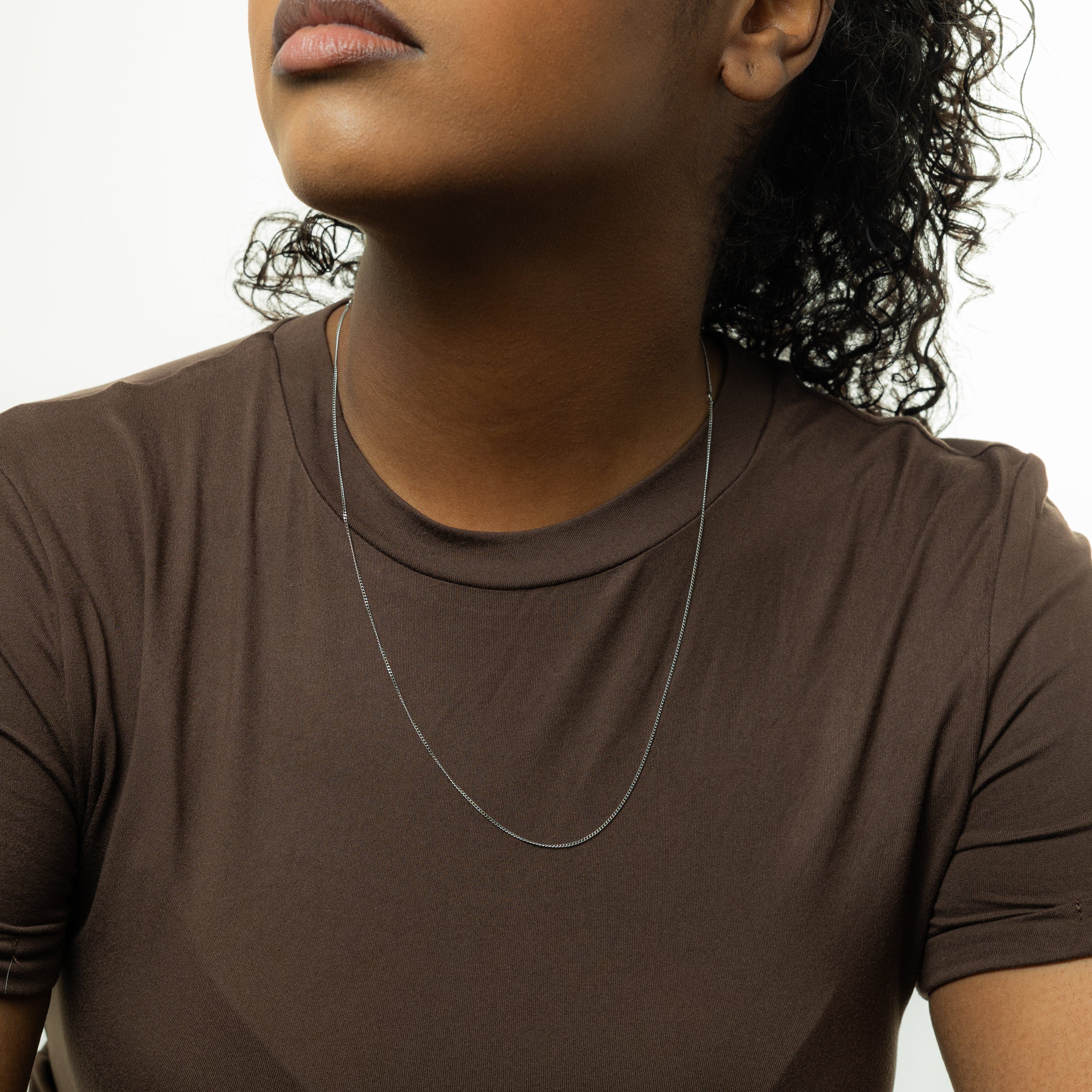 Elegant Invisible Curb Chain Necklace displayed in a velvet pouch, highlighting its premium quality.