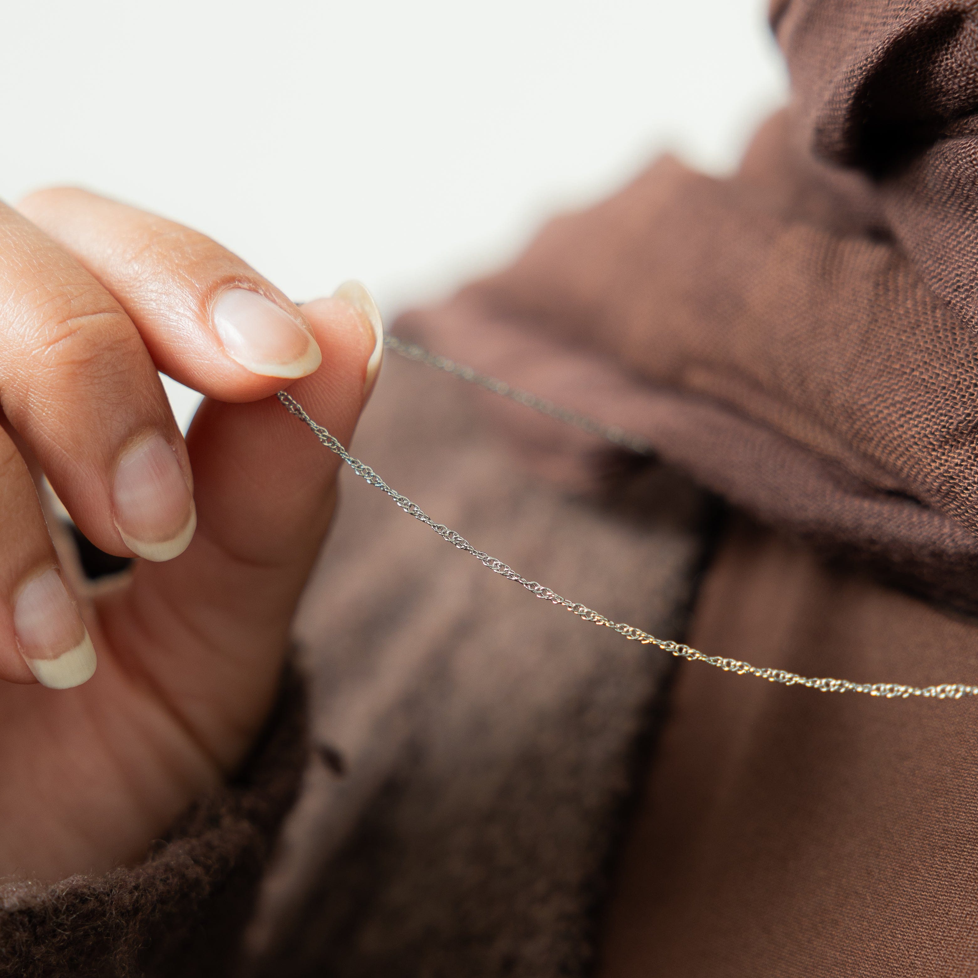 Elegant twisted gold chain necklace displayed on a model, showcasing its delicate design.