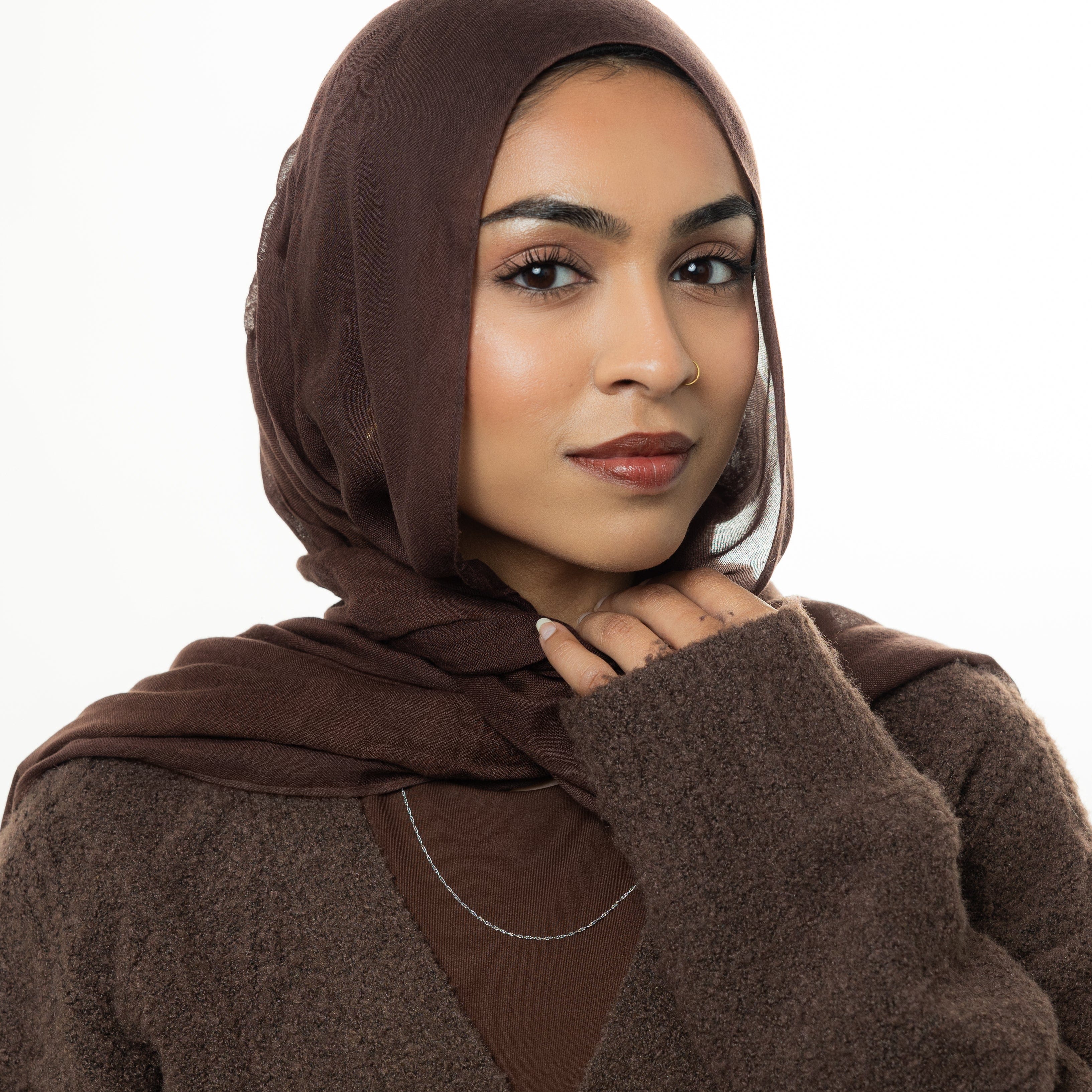 The gold twisted chain necklace styled with casual and formal outfits, illustrating its versatility.