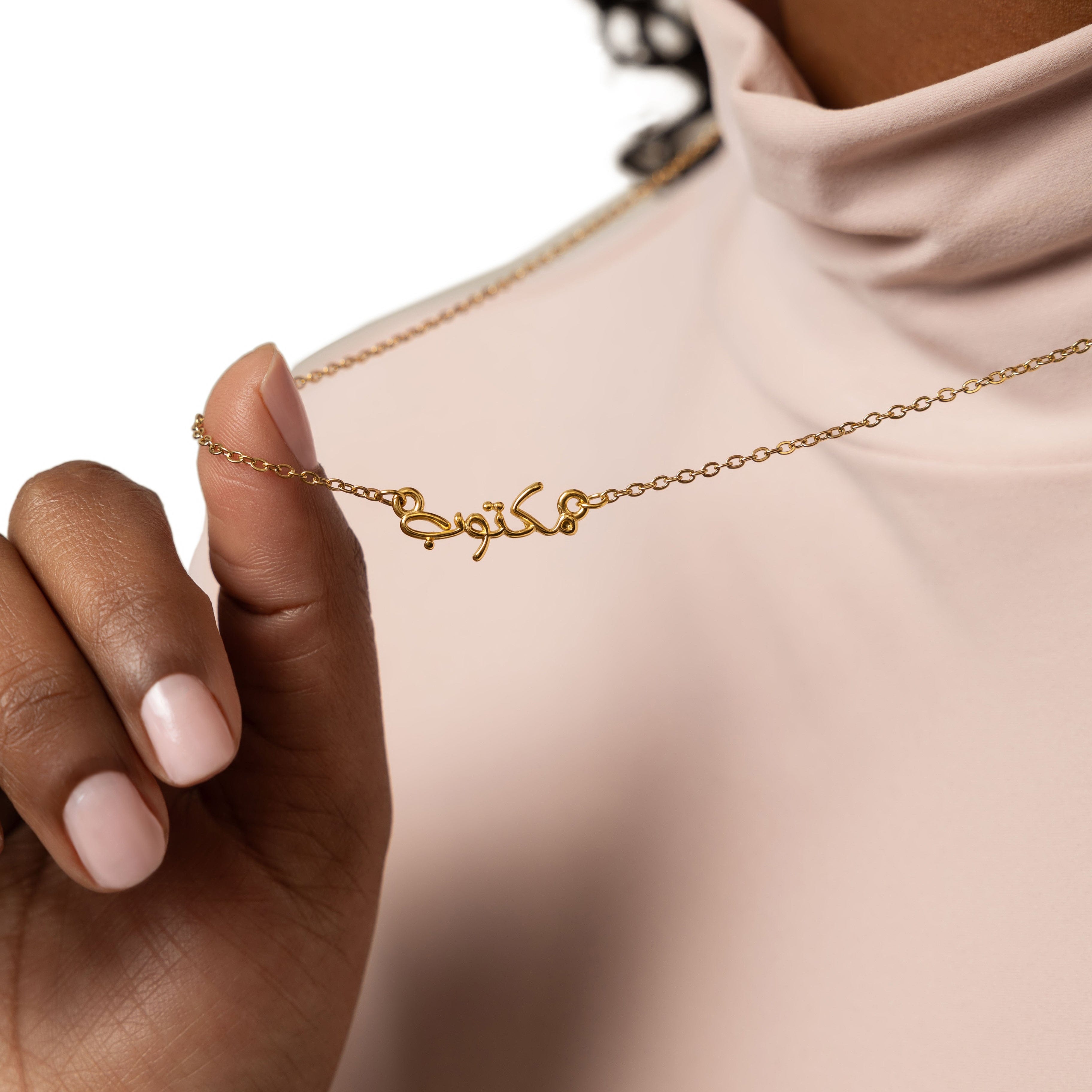 Maktub bubble necklace showcasing Arabic calligraphy on a gold-plated chain.