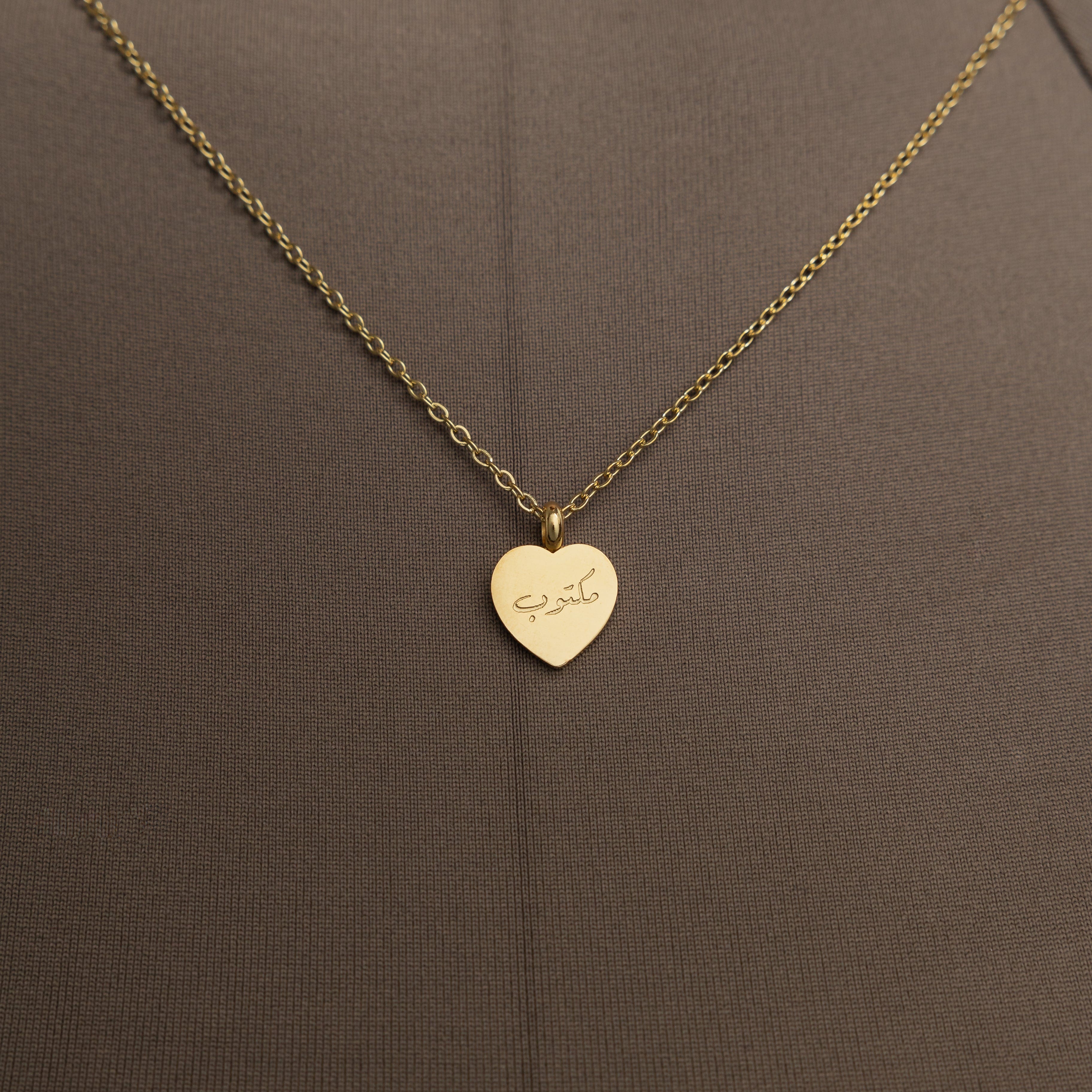 Gold charm necklace displayed on a soft velvet pouch, symbolizing personal journeys.