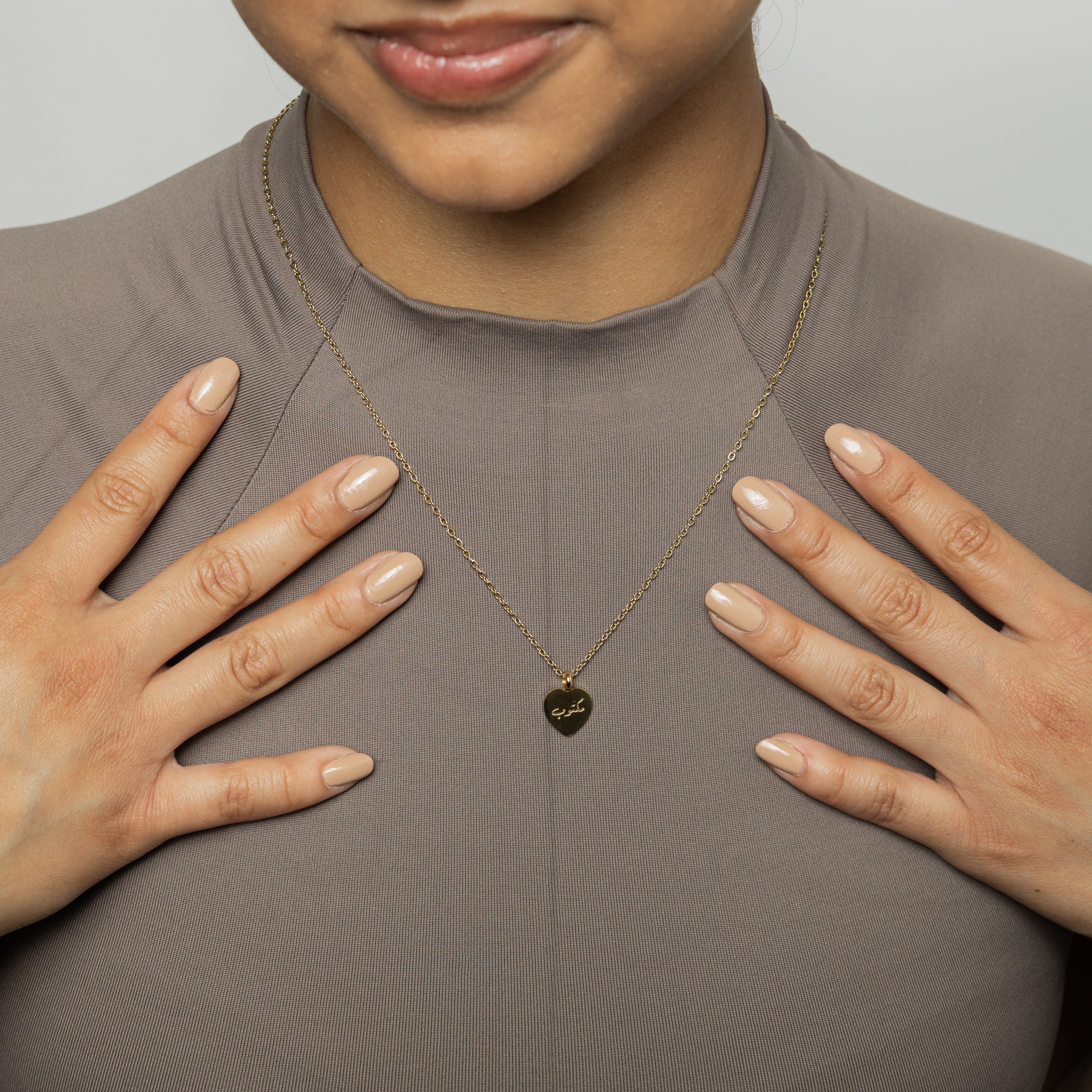 Close-up of the destined charm pendant showcasing its intricate design and gold plating.