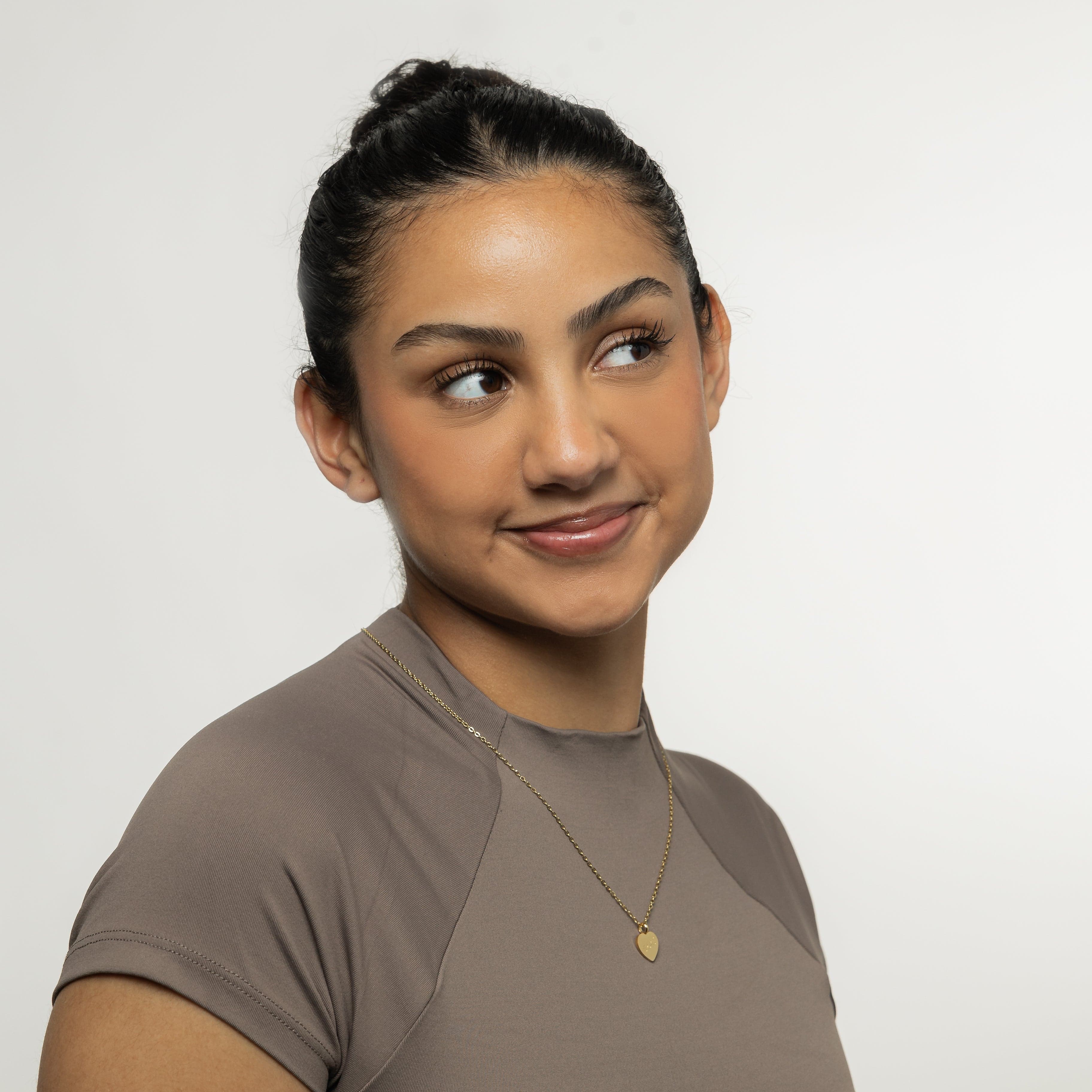 Model wearing the charm necklace, highlighting its elegant design and versatility.
