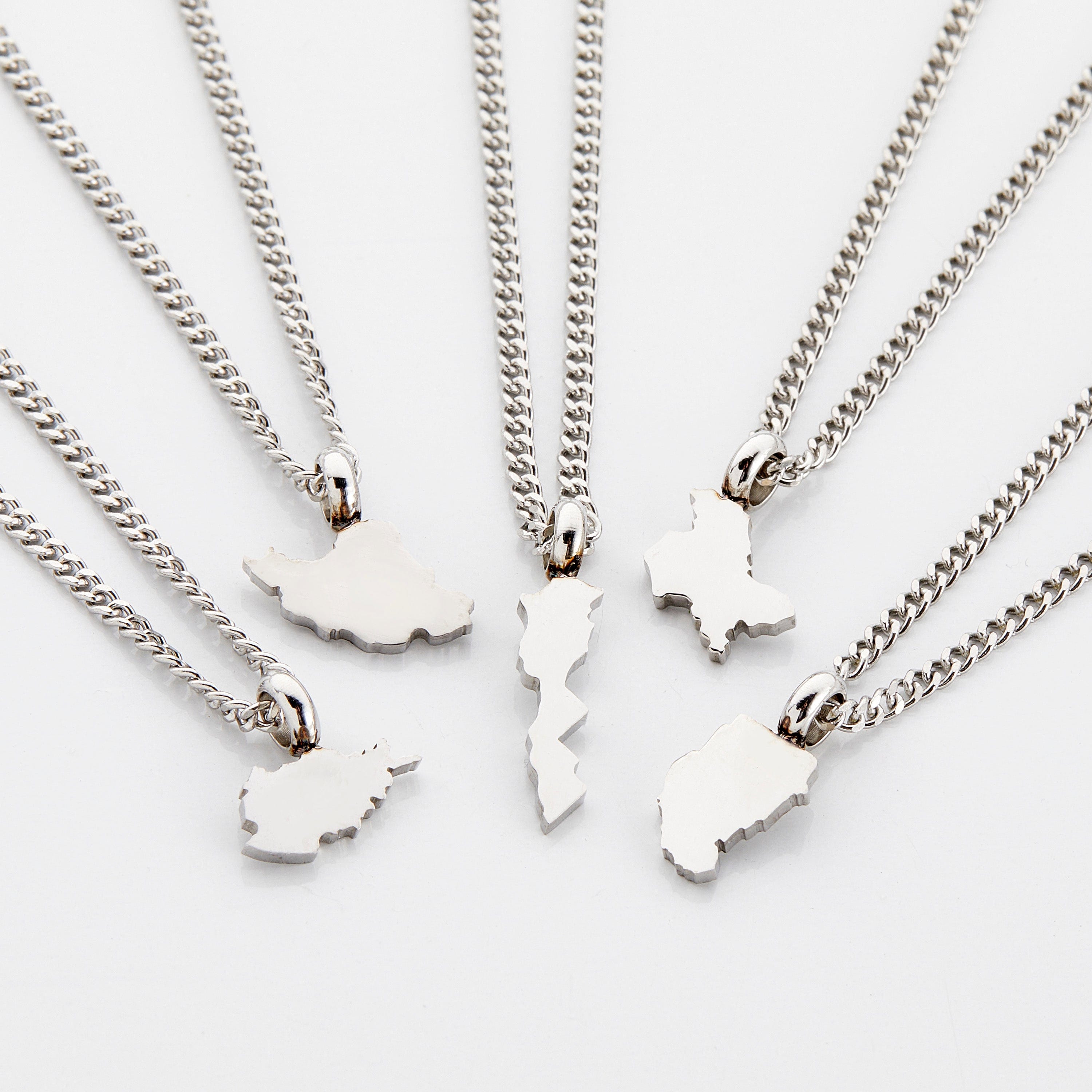 Personalized country map necklace for kids displayed on a velvet pouch