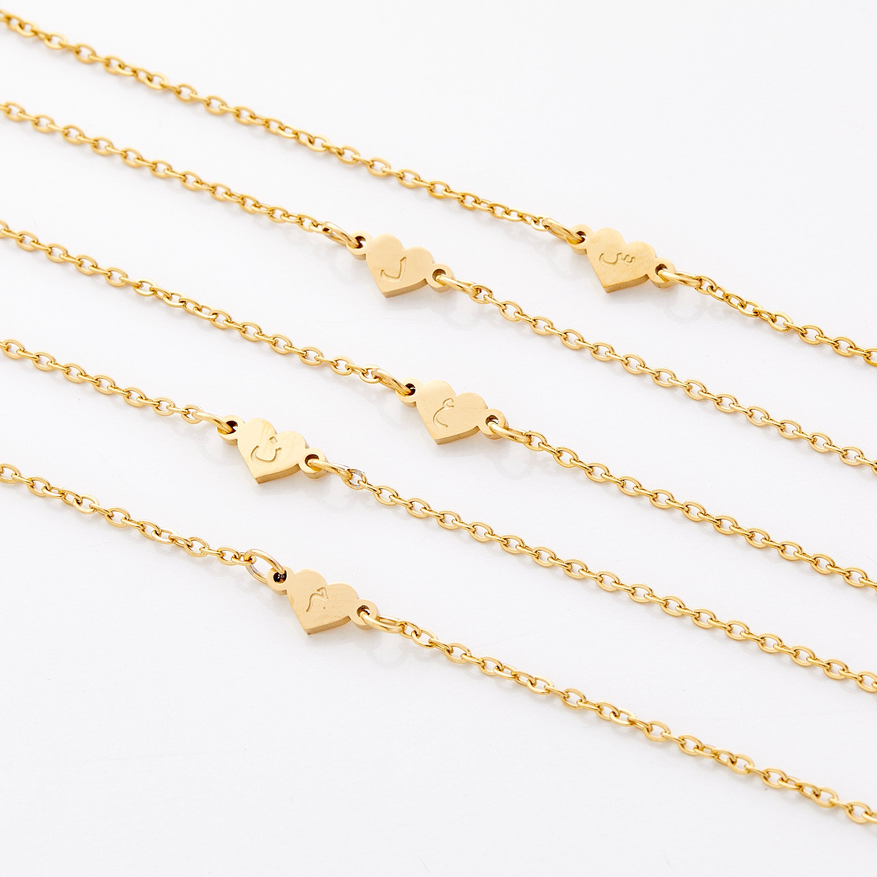 Personalized heart name bracelet for kids with letter pendant displayed elegantly.