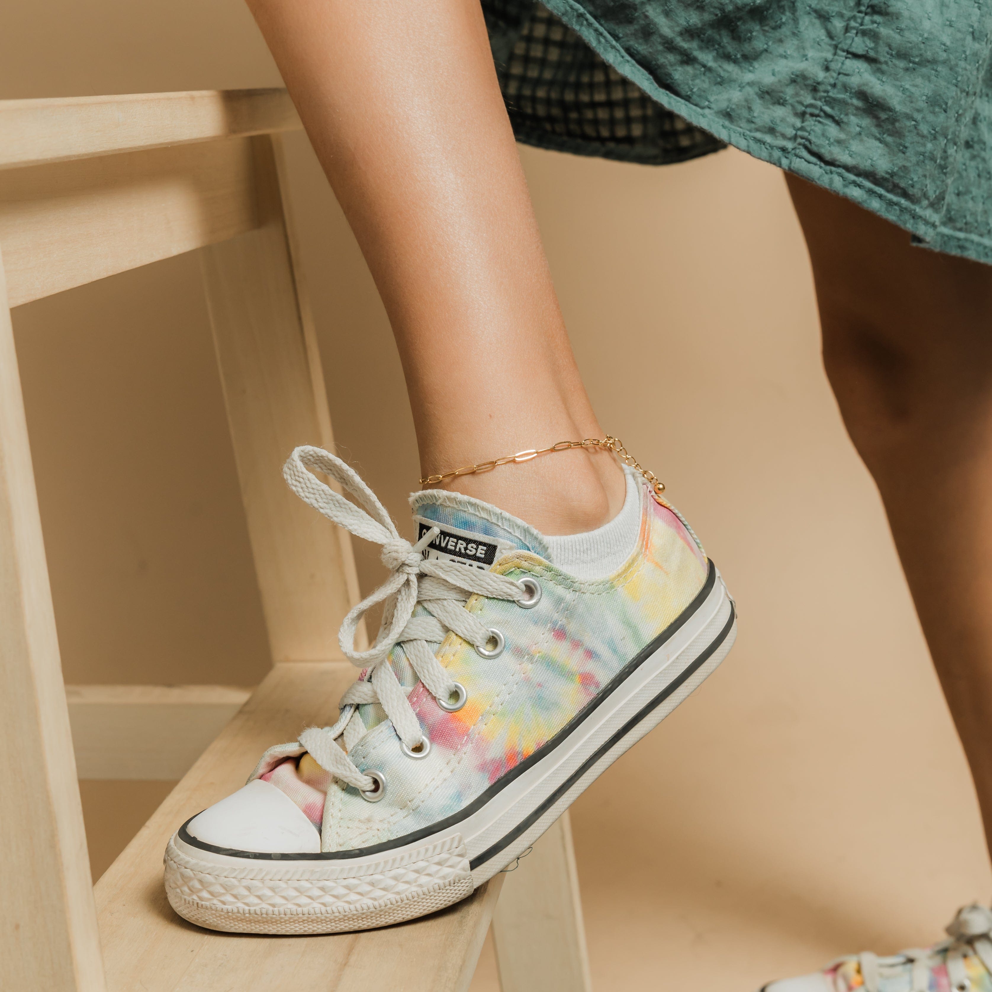 Model wearing the gold anklet during a casual outing, highlighting its everyday elegance.