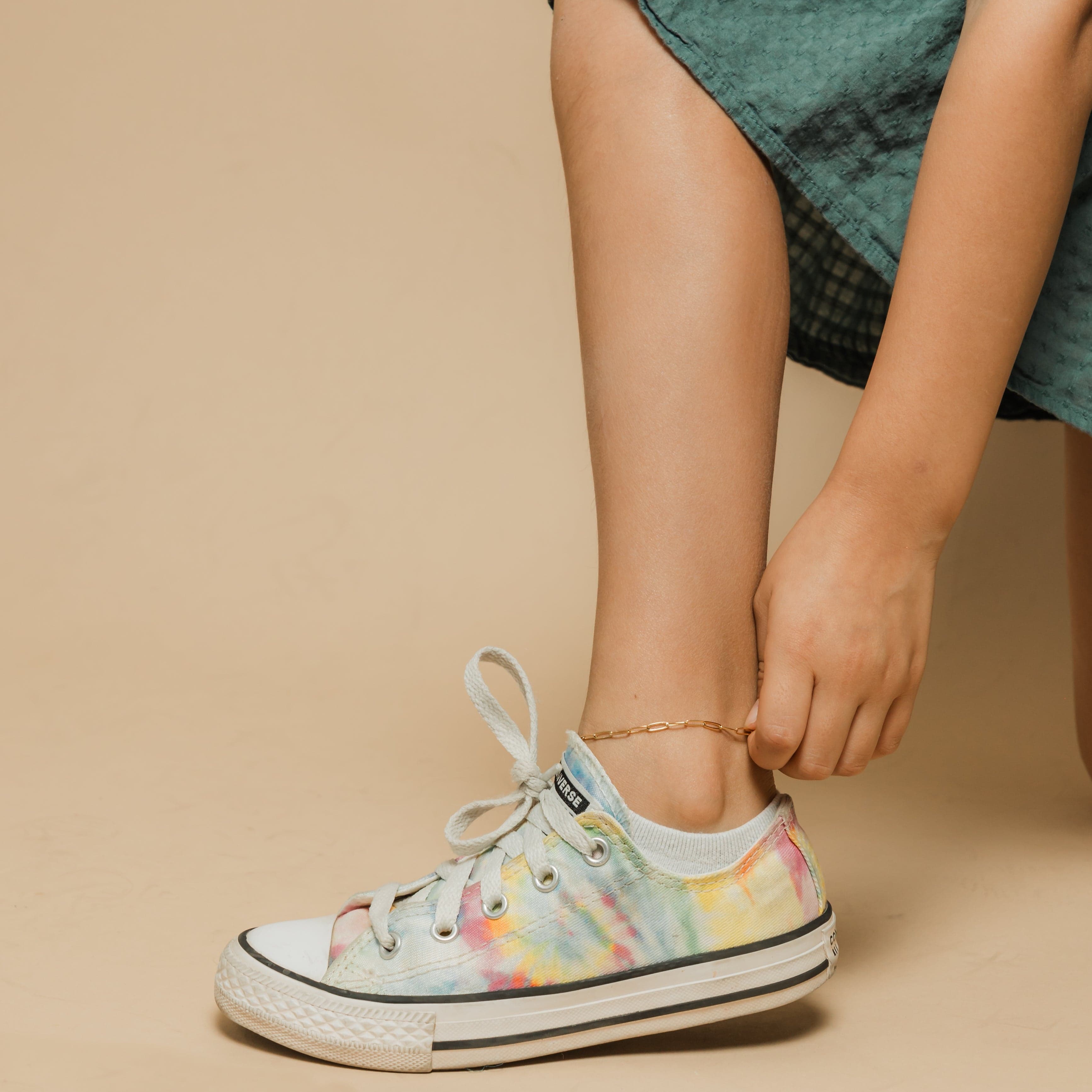 Model wearing the gold anklet during a casual outing, highlighting its everyday elegance.