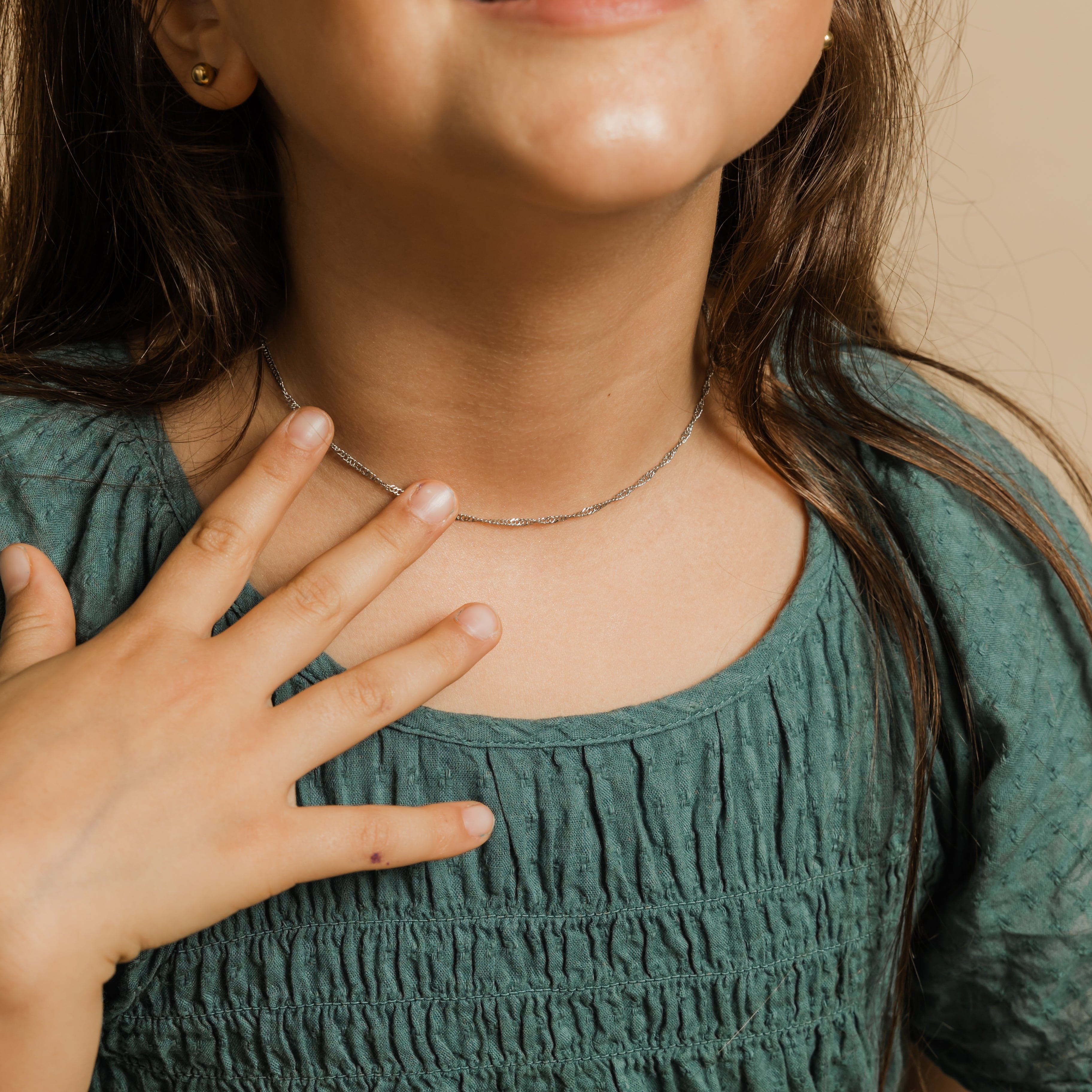 Radiant twisted chain necklace for girls, showcasing its elegant oval links under sunlight.